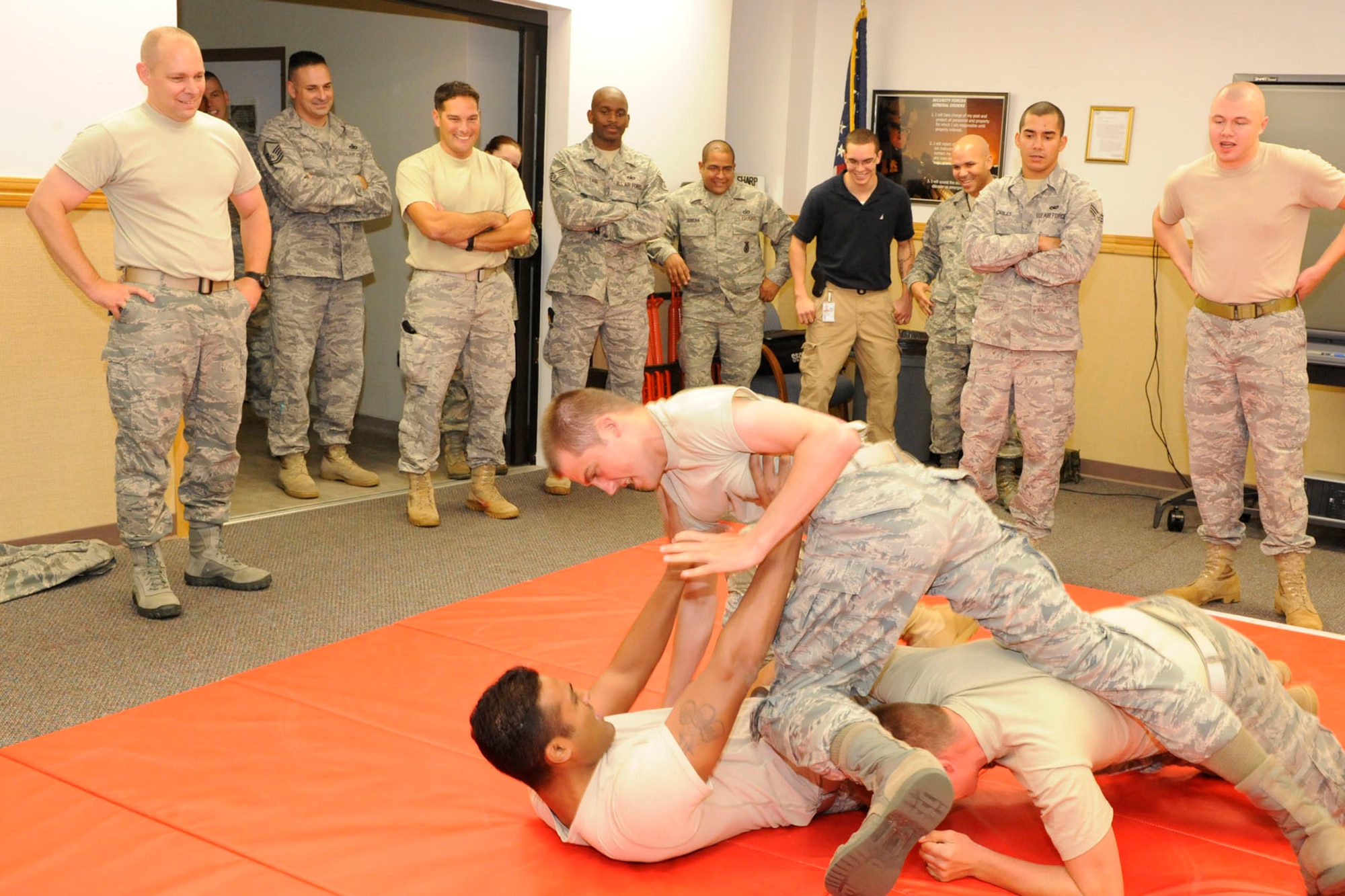 Members of the 65th Security Forces Squadron practice combatives while Chief Dennis Vannorsdall, 3rd Air Force Command Chief Master Sgt. (far left), looks on with other SFS members during a pre-TDY training at Lajes Field, Oct. 12, 2010.  Combative training techniques are useful to military members when in hand-to-hand combat.  This specialized training includes verbal judo and self-defense.  
(U. S. Photo by Guido Melo)