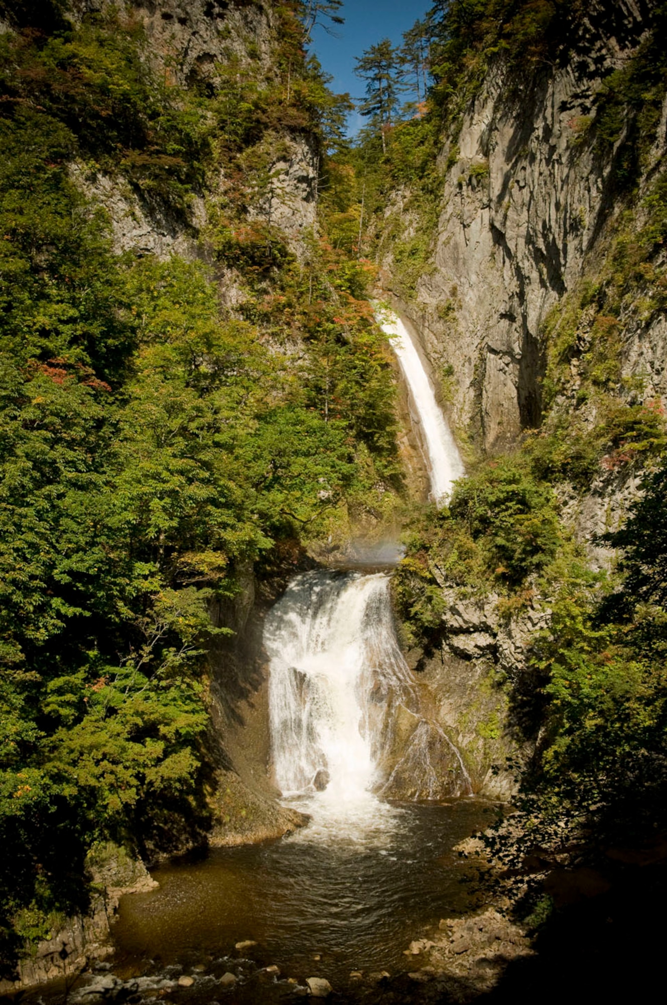 Matsuminotaki Falls, heavily flowing from a recent rainfall, cut through a gorge of basalt rock formations, Oct. 11, 2010, in Aomori Prefecture, Japan. The falls are located on the upper Osegawa River and are one of the locations 35th Force Support Squadron Outdoor Recreation guides took service members and their families to during an adventure program. To learn more about their programs, call (315) - 226-3480. (U.S Air Force photo/Senior Airman Jessica Lockoski/Released