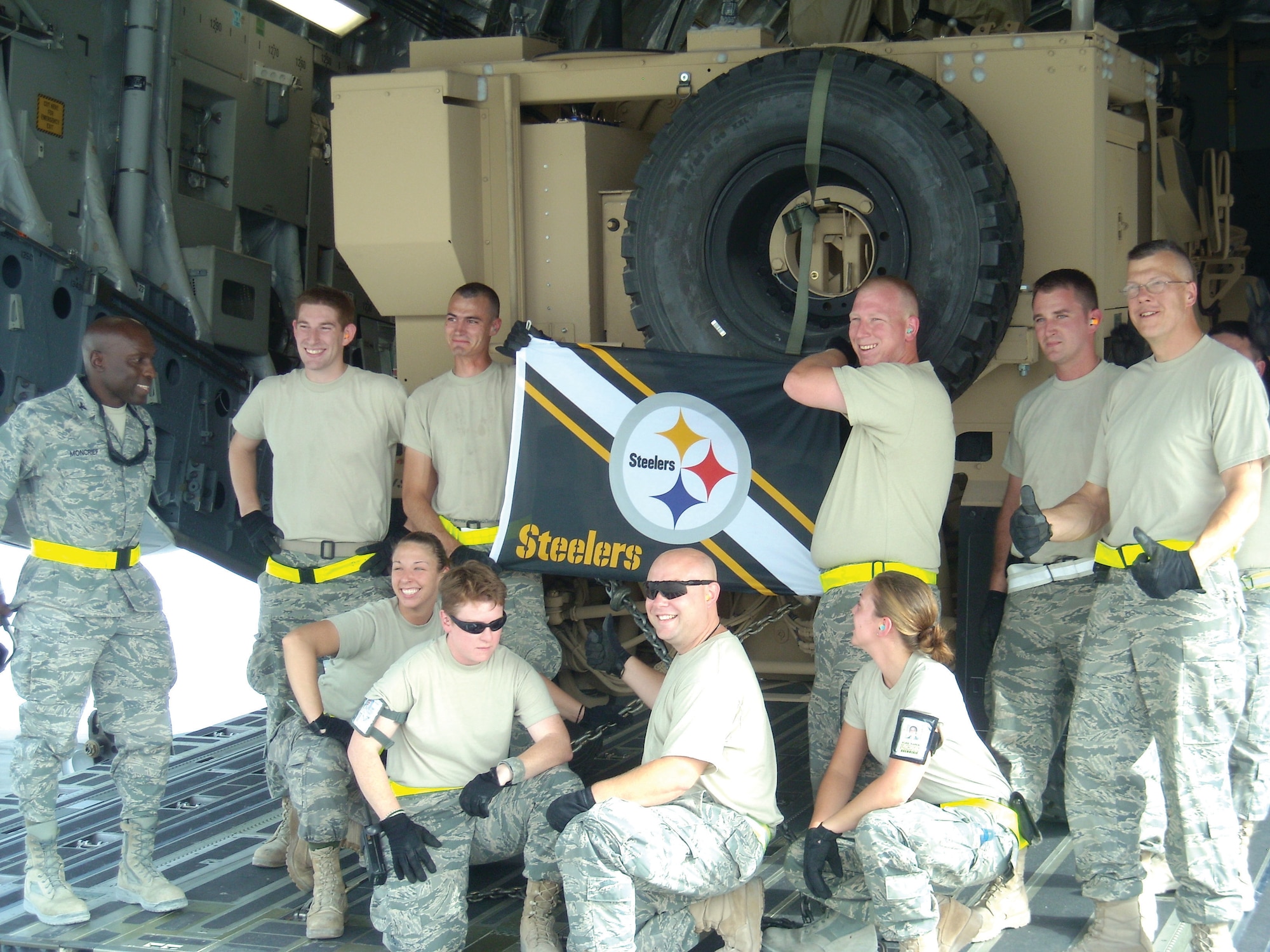 Airmen from ISA AB share a moment together as they finish loading the last M-ATV onto a C-17. The Airmen found a way to load five M-ATVs instead of four, enabling them to complete their mission months ahead of schedule. (U.S. Air Force photo/ Tech. Sgt. Kevin. Nichols)