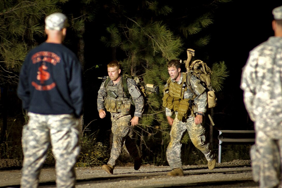 A Us Army Sniper Instructor Left Looks On As Two Soldiers Finish