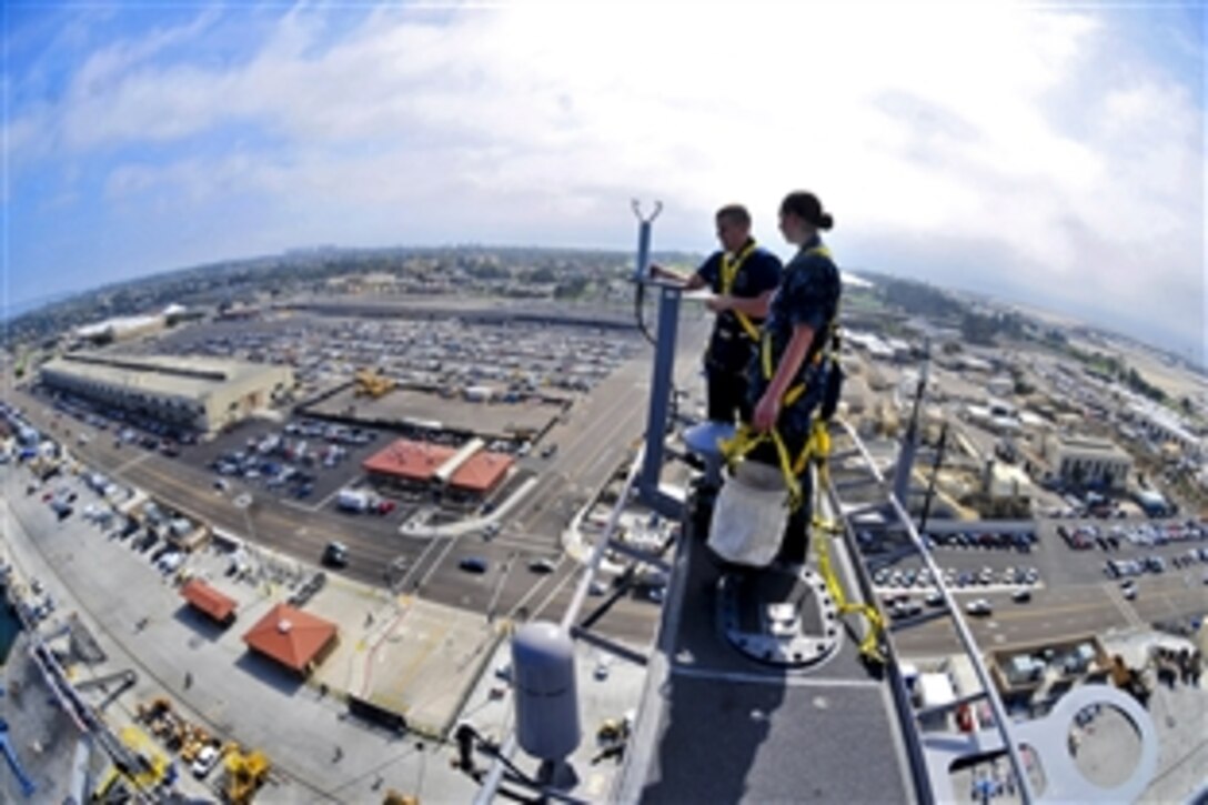 U.S. Navy Petty Officers 3rd Class Sean Kilcoyne and Laura Colliton conduct maintenance on the main mast of the aircraft carrier USS Carl Vinson while preparing for the ship's Board of Inspection and Survey assessment in San Diego, Oct. 13, 2010.