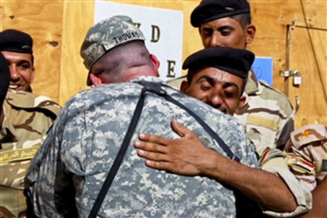 U.S. Army Staff Sgt. Richard Thomas, left, congratulates an Iraqi soldier graduating from an equipment training course on Joint Security Station Al Rashid in Baghdad, Oct. 7, 2010. Thomas, who helped instruct the Iraqi soldiers, is an armor crewman assigned to the 3rd Infantry Division's 3rd Battalion, 69th Armor Regiment, 1st Advise and Assist Brigade. 
