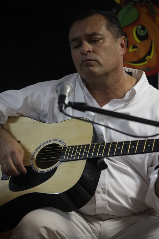 Chief Petty Officer Marco Escobar, a hospital corpsman chief with 26th Marine Expeditionary Unit, plays the guitar and sings a traditional Spanish song during a talent show in celebration of Hispanic Heritage Month aboard USS Kearsarge, Oct. 16, 2010. 26th MEU is currently embarked aboard the ships of Kearsarge Amphibious Ready Group and conducting training in the 5th Fleet area of responsibility.