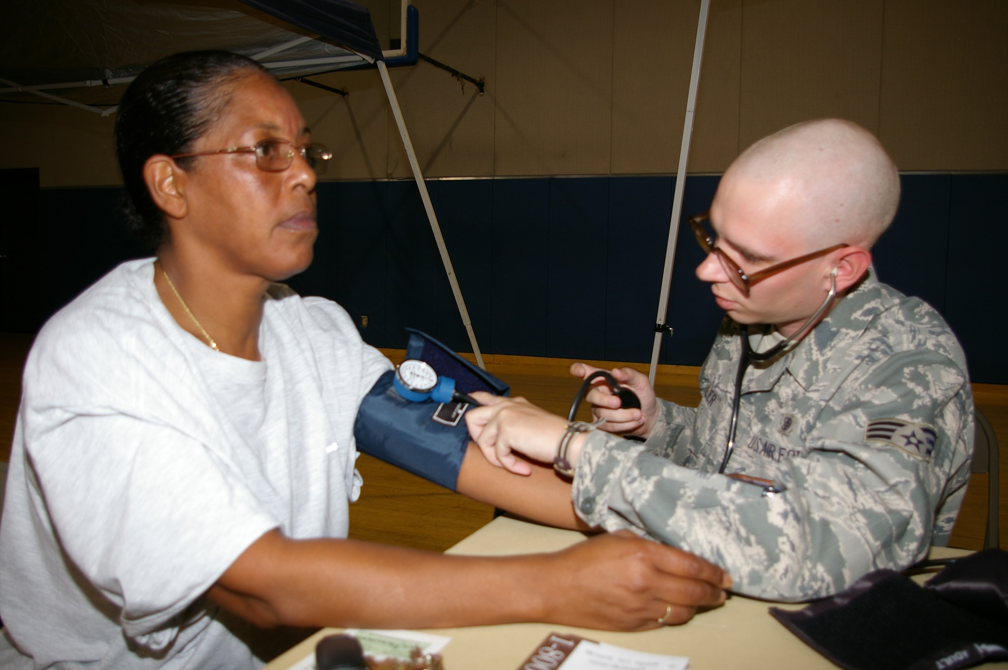 Senior Master Sgt. Rhonda Sumlar, 50th Aerial Port Squadron superintendent of training, sits quietly as Senior Airman Eric Feller, 752nd Medical Squadron medical technician, measures her blood pressure during the March Fitness Fair.  (U.S. Air Force photo by Master Sgt. Linda Welz)