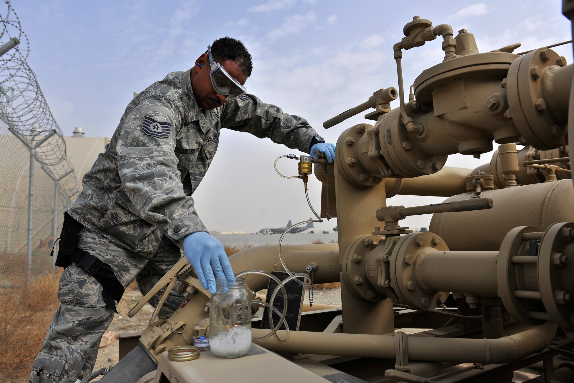 Tech Sgt. Kerry Miller, the 455th Expeditionary Logistics Readiness Squadron non-commissioned officer in charge of the laboratory and day shift distribution supervisor, performs a weekly inspection of a fuel filtering system at Bagram Air Field, Afghanistan, Oct. 14, 2010. The inspection ensures quality of the fuel by ensuring that no debris or water has contaminated the fuel. The Petroleum Oils and Lubricants flight, ranked fourth in the Air Force for most gallons pumped, pumps 8 to 9 million gallons monthly worth about $16 million. Sergeant Miller is a native of Harrisburg, Pa. (U.S. Air Force photo/Staff Sgt. Christopher Boitz)