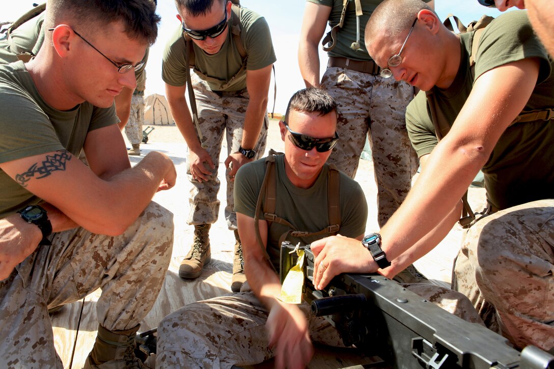 Lance Cpl. Josh M. Luck, a motor transportation operator with Regimental Combat Team 8, 2nd Marine Division, disassembles a M2 .50 caliber machine gun as other Marines with the regiment wait their turn, Oct. 17.  The regiment, based at Camp Lejeune, N.C., is training at Marine Corps Air Station Yuma, Ariz., to better prepare themselves for an upcoming deployment to Afghanistan.