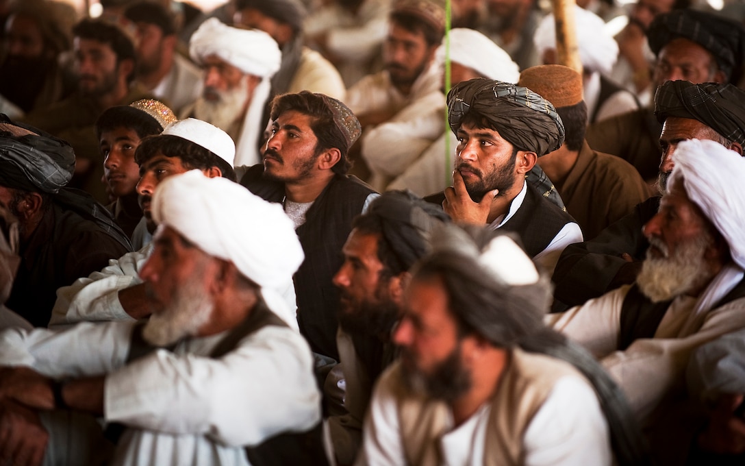 Afghan farmers listen to the Nawa District governor, Haji Abdul Manaf, during a shura for the Helmand province food zone program in Nawa, Afghanistan, Oct. 17, 2010. Hundreds of farmers attended the shura to hear the Helmand deputy governor and Nawa District governor address concerns about the food program, which provides farmers with alternative crop options to poppy.