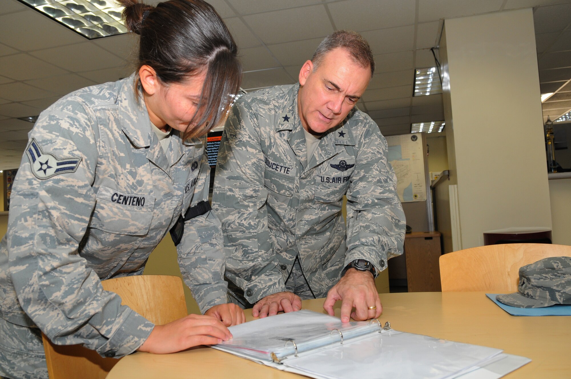Airman 1st Class Jamaira Centeno, 36th Operations Support Squadron, Airfield Management operations coordinator shows Brig. Gen. John Doucette, 36th Wing commander, the current flight plans before surprising her with a certificate and coin for being selected Andersen's Best, Oct. 12 at Andersen Air Force Base, Guam. She was nominated by her supervisor for her outstanding performance, dedication, commitment to excellence and performing above and beyond expectations during the Commands largest joint-service exercise, Valiant Shield 2010, more than 30 distinguished visitor missions and a recent medical evacuation.(U.S. Air Force photo/ Senior Airman Nichelle Anderson)