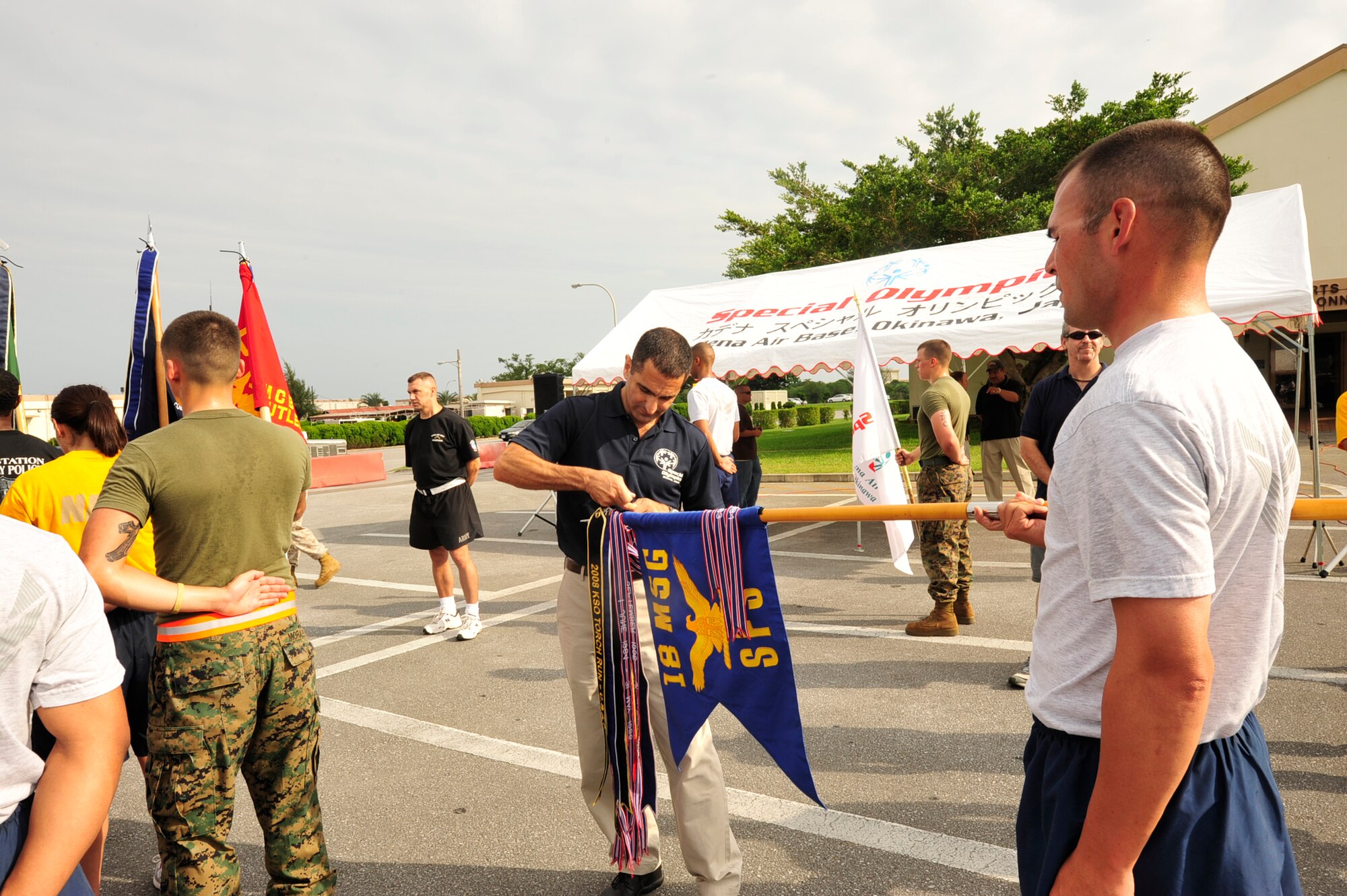 Col. David Nahom, 18 Operations Group Commander ties a banner to the final flag bearer during the Kadena Special Olympics Torch Run here at Kadena Air Base, Japan October 16th, 2010.  The torch run is one of the last fundraisers over a period of six months leading up to game day. (U.S. Air Force photo/Staff Sgt. Lakisha A. Croley)