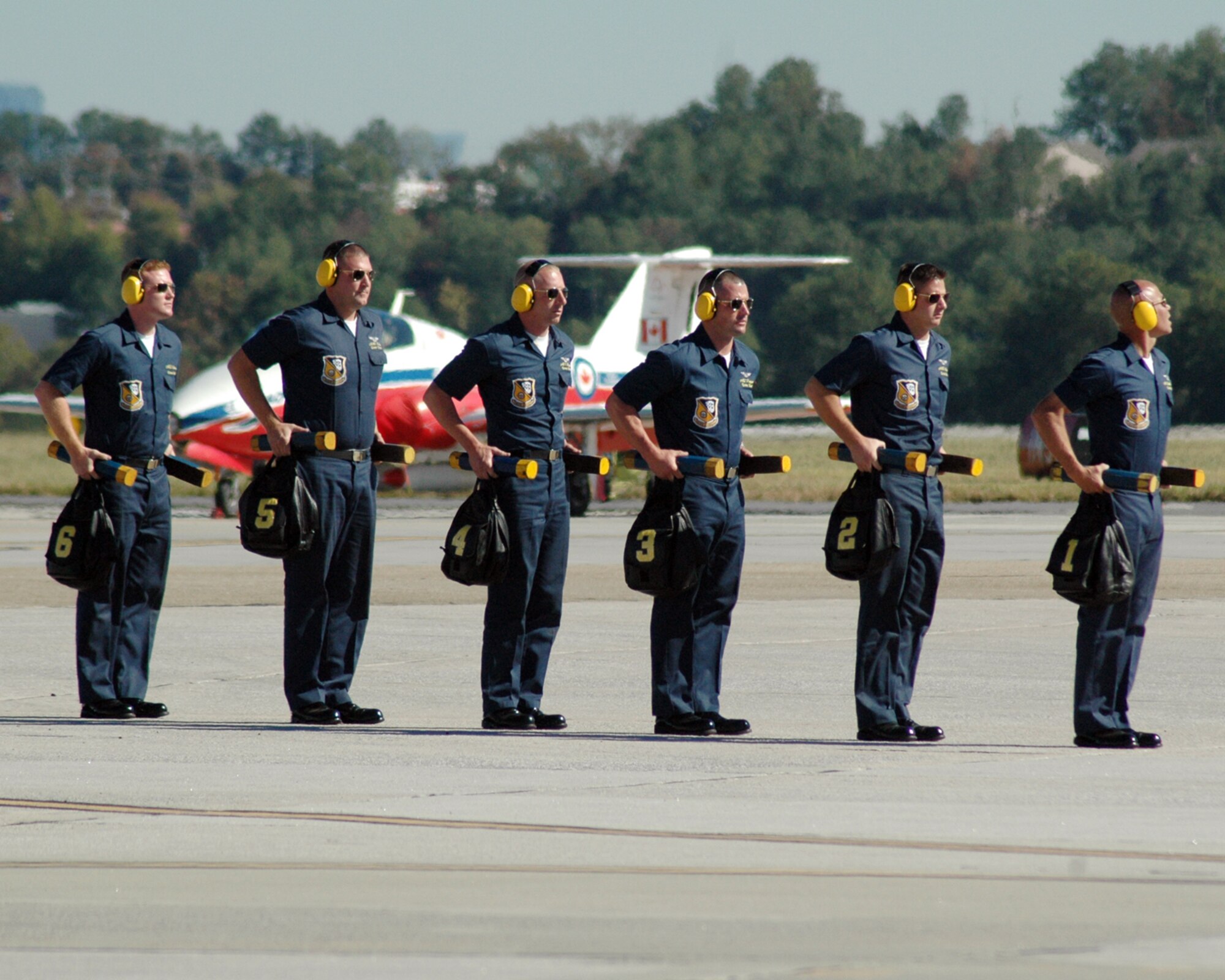 The Blue Angels' crew chiefs await the arrival of their aircraft during the Wings Over Atlanta Air Show.  The crew technicians provide a visual aspect to the Blue Angels ceremony as they prep the F/A-18 Hornet aircrafts for takeoff and receive the aircrafts after their landing.  (U.S. Air Force photo/ Master Sgt. Travon Dennis)