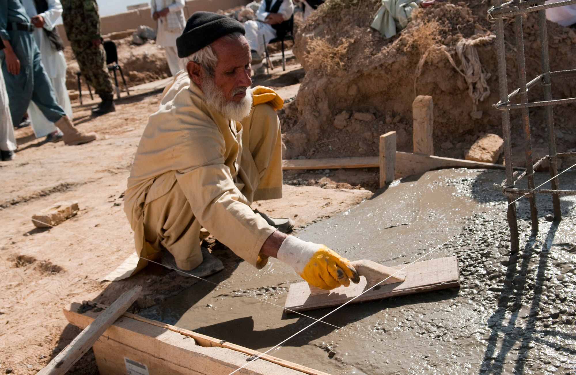 QALAT CITY, Afghanistan -- An Afghan man smoothes freshly poured concrete at the site of the new Surri Comprehensive Health Clinic near Forward Operating Base Wolverine, Zabul Province, Oct. 15, 2010. The clinic will provide outpatient care, immunizations, basic laboratory practices and five beds for inpatient care. (U.S. Air Force photo/Senior Airman Nathanael Callon/Released)