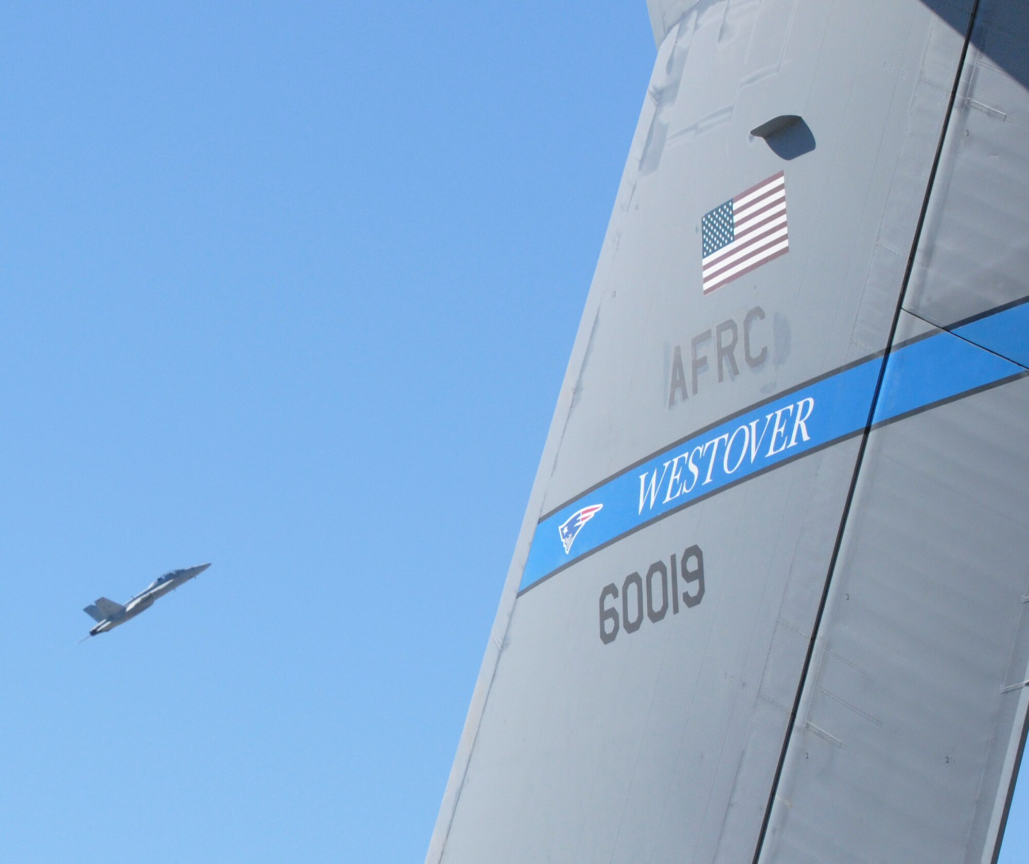 A C-5A Galaxy from Westover Air Force Base tail flash provides a perspective view of the F/A-18 Hornet performing its aerobatic manuevers during the Wings Over Atlanta Air Show Oct. 16.  (U.S. Air Force photo/Master Sgt. Stan Coleman.