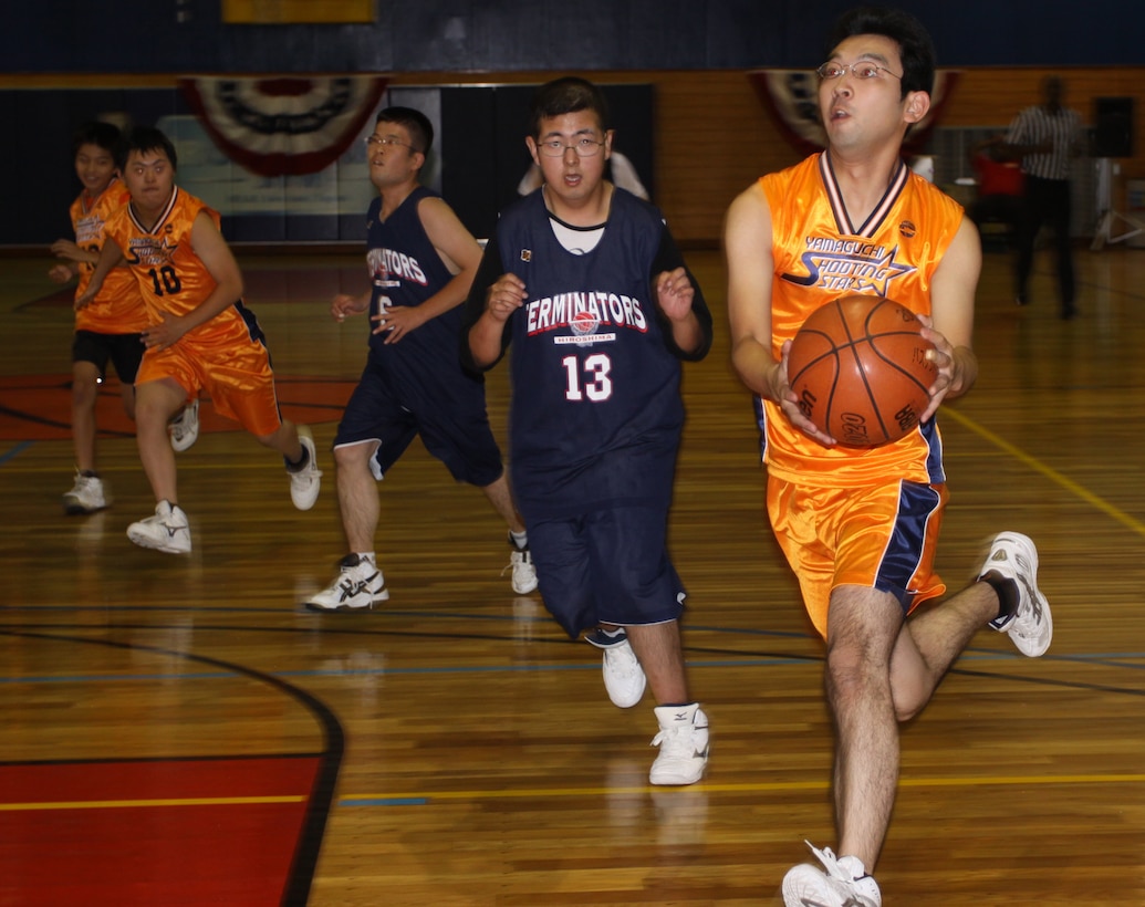 A basketball player on the Yamaguchi Shooting Stars prepares to layup a basket during a Special Olympics game at the sports courts in the IronWorks Gym here Sunday. Participants competed against one another and also played in friendly games with the volunteers. Many of the volunteers said they enjoyed being able to get involved with the children through the different events.