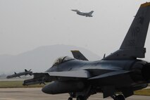 U.S. Air Force F-16 Fighting Falcon aircraft taxi to the runway as another takes off Oct. 18 at Kwangju Air Base, Republic of Korea, during exercise Max Thunder 10-02. (U.S. Air Force photo/Staff Sgt. Eric Burks)