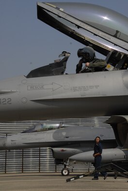 Maj. Jonathan Thomassee, 36th Fighter Squadron pilot, straps into the cockpit of an F-16 Fighting Falcon aircraft as Senior Airman Jonicko Dela Cruz, 51st Aircraft Maintenance Squadron, looks on during exercise Max Thunder 10-02 Oct. 18 at Kwangju Air Base, Republic of Korea. Both Airmen are from Osan Air Base, ROK. (U.S. Air Force photo/Staff Sgt. Eric Burks)