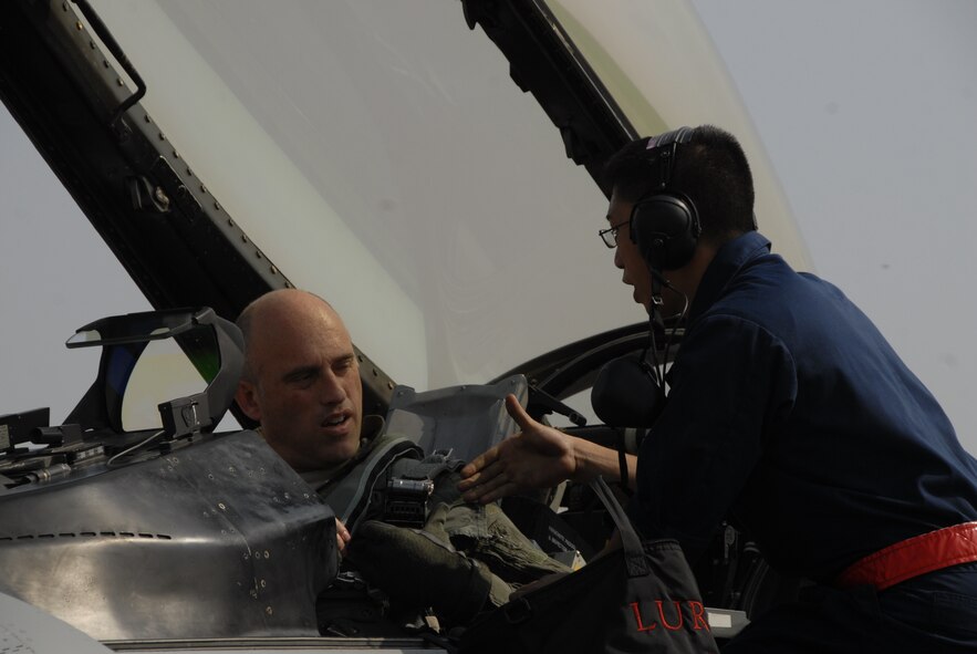 Senior Airman Jonicko Dela Cruz, 51st Aircraft Maintenance Squadron, right, extends a handshake to Lt. Col. Jon Wilkinson, 51st Operations Support Squadron commander, Oct. 18 at Kwangju Air Base, Republic of Korea, during exercise Max Thunder 10-02. Both Airmen are from Osan Air Base, ROK. (U.S. Air Force photo/Staff Sgt. Eric Burks)