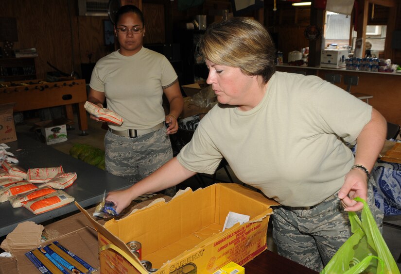 SOTO CANO AIR BASE, Honduras --  Master Sgt. Danielle McClarin (right) and Tech. Sgt. Diora Farrar, both with the Medical Element here, help to pack bags full of food and other supplies Oct. 15 in preparation for the Chapel Hike. Team Bravo members volunteer to help the Soto Cano Air Base Friendship Chapel deliver supplies to remote villages. (U.S. Air Force photo/Capt. John Stamm)