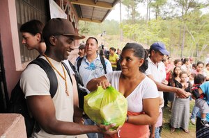 SAN JERONIMO, Honduras --  Staff Sgt. Joel Hart, with Joint Task Force-Bravo, hands a bag of food and other supplies to a local woman during a Chapel Hike here Oct. 16. Besides handing out supplies, Team Bravo members visited with the villagers and provided games for the children. (U.S. Air Force photo/Tech. Sgt. Benjamin Rojek)