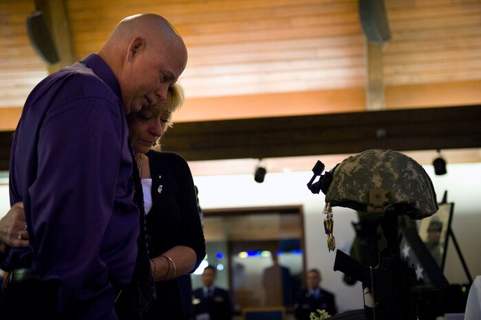 NELLIS AIR FORCE BASE, Nev. -- John and Joy Buras, parents of Senior Airman Michael Buras, mourn the battle cross of Senior Airman Buras inside the base chapel during a memorial service Oct. 15. Senior Airman Buras was an explosive ordnance disposal journeyman assigned to the 99th Civil Engineer Squadron. Airman Buras was killed in action while deployed to Afghanistan while responding to an improvised explosive device Sept. 21.  (U.S. Air Force photo by Senior Airman Brett Clashman/Released)
