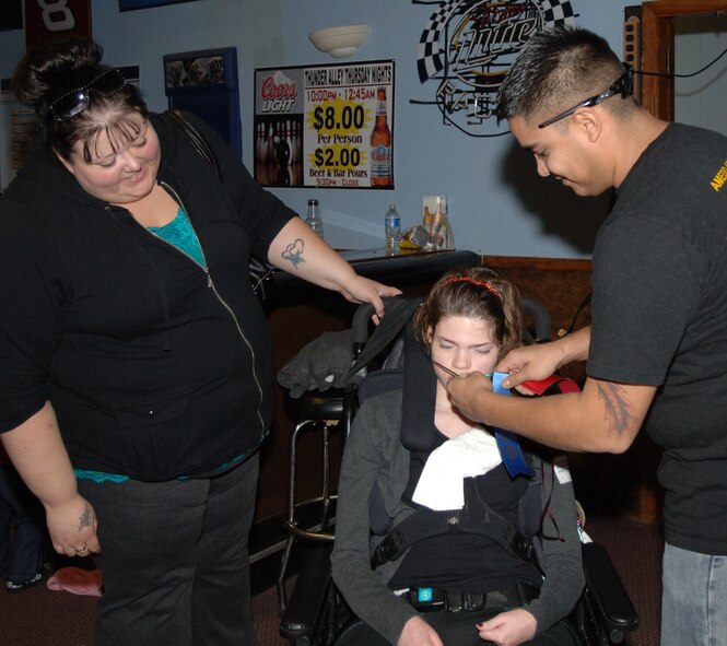 Senior Airman Jacob Chavez (right), 319th Logistics Readiness Squadron, awards the first place ribbon to a Special Olympics participant as her mom looks on, during the Special Olympics district bowling tournament Oct. 16 at Liberty Lanes in East Grand Forks, Minn. The Special Olympics offers year-round training and competition in 30 Olympic-type summer and winter sports and has been active in the Grand Forks, N.D., community since the mid-1970s. Members from the Grand Forks Air Force Base volunteered to help the participants bowl, award prizes and serve lunch. (U.S. Air Force photo by Airman 1st Class Rachel Waller)