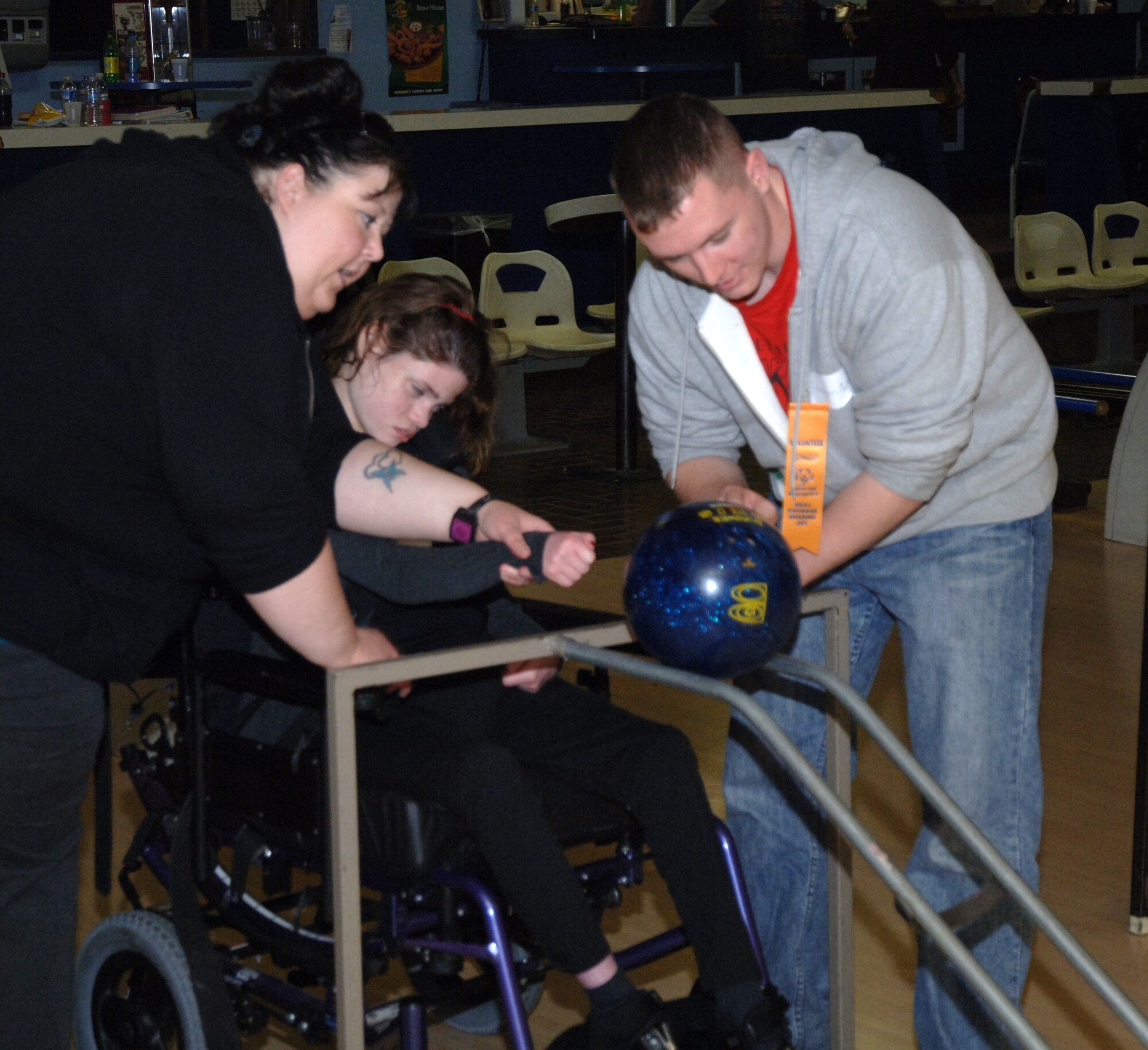 Airman 1st Class Steven Mathews (right), 319th Logistics Readiness Squadron, helps a Special Olympics participant bowl during a Special Olympics district bowling tournament Oct. 16 at Liberty Lanes in East Grand Forks, Minn. The Special Olympics offers year-round training and competition in 30 Olympic-type summer and winter sports and has been active in the Grand Forks, N.D., community since the mid-1970s. Members from the Grand Forks Air Force Base volunteered to help the participants bowl, award prizes and serve lunch. (U.S. Air Force photo by Airman 1st Class Rachel Waller) 