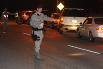 MINOT AIR FORCE BASE, N.D. -- Tech. Sgt. Chris Stevens, 5th Security Forces Squadron patrolman, directs traffic during Operation Prairie Hawk here Oct. 10. First sergeants from both the 5th Bomb Wing and the 91st Missile Wing in partnership with the Drug Demand Reduction Office, Air Force Office of Special Investigations and Judge Advocate General office conducted the sweep to present a clear deterrent to drug use. The ordered sweep is crucial to ensuring Airmen are fit for duty and key to meeting uncompromising adherence to all directives. (U.S. Air Force photo by Tech. Sgt. Lee A. Osberry Jr.)