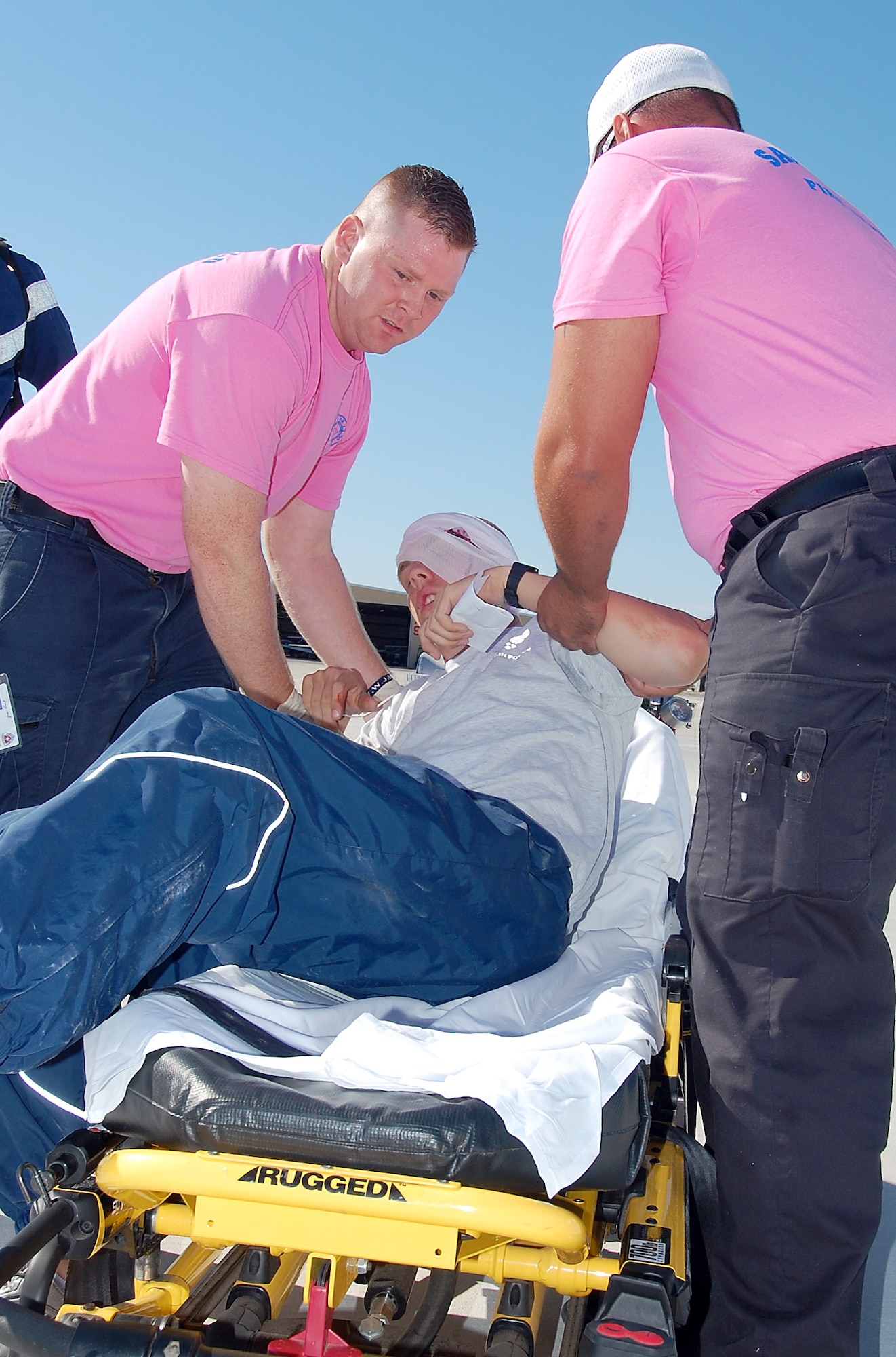 SAN ANGELO, Texas – From left: Jordan Russell and David Geron, San Angelo Fire Department Paramedics, lift  a victim onto a stretcher for ambulance transport during a training exercise at the Mathis Field San Angelo Regional Airport Oct. 14.  Airmen from Goodfellow teamed up with emergency response teams from the Airport and city for an exercise simulating a collision between a T-38 and civilian aircraft. (U.S. Air Force photo/ Staff Sgt. Heather L. Rodgers)