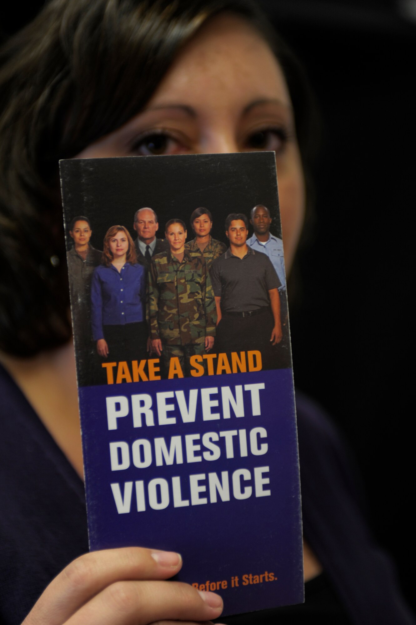 Tyleen Caffrey, Family Advocacy Program outreach manager at Cannon Air Force Base, N.M., display a pamphlet about domestic violence during a presentation at the base exchange, Oct, 15. October is Domestic Violence Awareness Month. (U.S. Air Force photo by Airman Ericka Engblom)