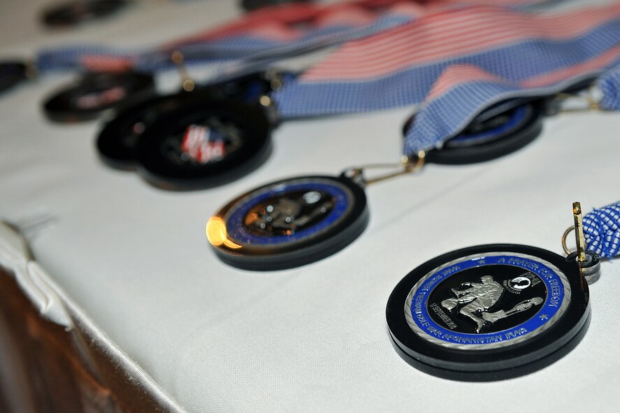 OFFUTT AIR FORCE BASE, Neb. - During the 16th Annual Prisoner of War/Missing in Action remembrance ceremony held at the Patriot Club Oct. 13, medallions were presented to several former POWs and survivng family members. As part of the ceremony, a POW/MIA table is set by the Offutt Honor Guard with specific symbolic items in rememberance and to honor all American former prisoners of war, servicemembers and civilians still unaccounted for, and their families. These items include a slice of lemon to represent the bitter fate of prisoners of war or those missing in action, a pinch of salt to represent the tears shed by the one missing or captured and their family, and an inverted glass showing the inability of those listed as POW/MIA to share in the toast for the evening. U.S. Air Force photo by Charles Haymond 
   

U.S. Air Force Photo Charles Haymond