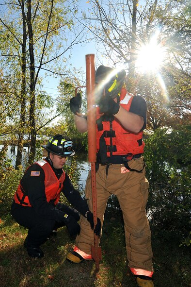 OFFUTT AIR FORCE BASE, Neb. - Two members of the 55th Civil Engineering Squadron pound support posts into the ground during a simulated hazardous material major accident response exercise near the base lake Oct. 15. This type of training allows various agencies to work on their response times, better coordinate with different organizations and sharpen their awareness and overall abilities if an accident were to happen. U.S. Air Force photo by Charles Haymond