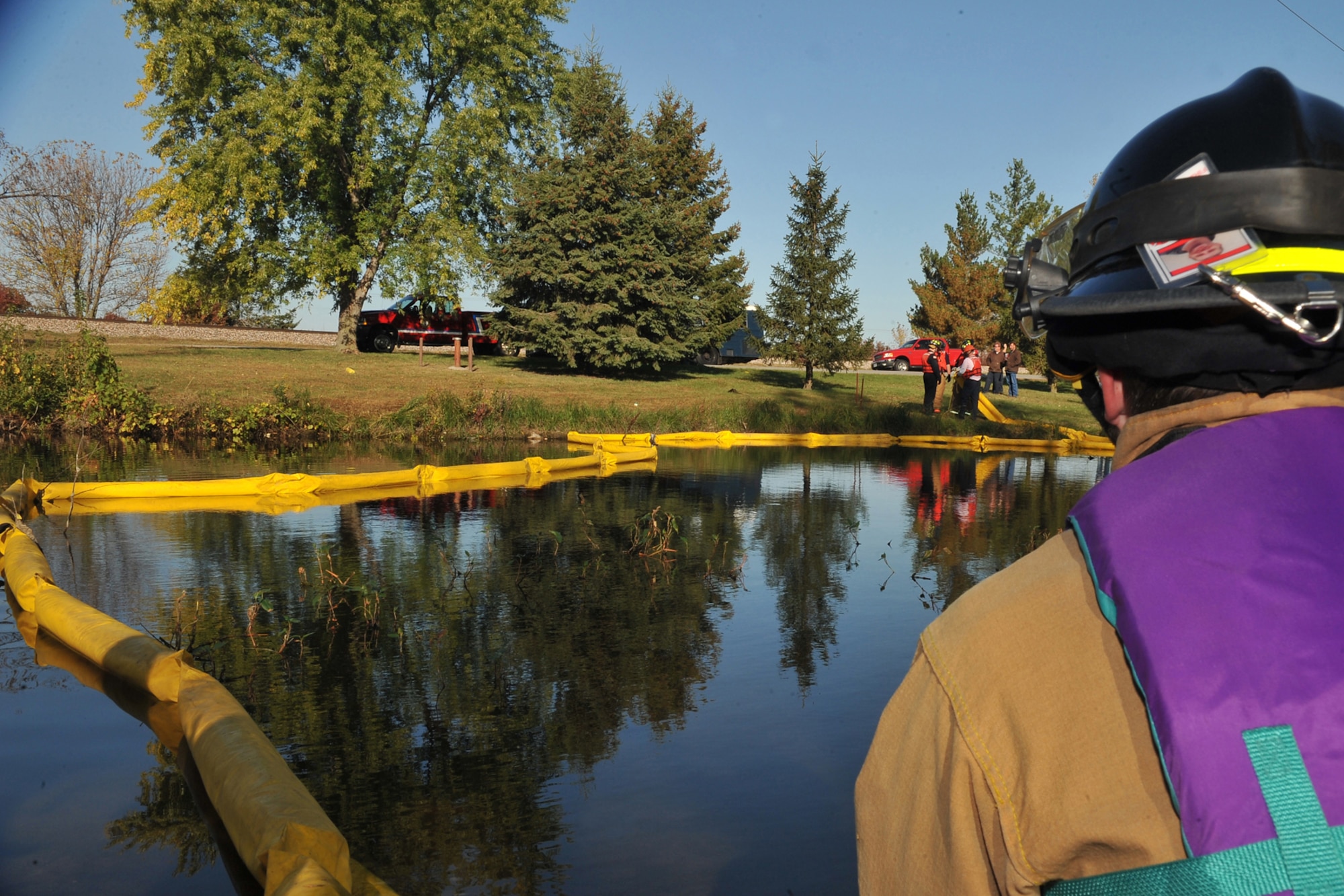 OFFUTT AIR FORCE BASE, Neb. - David Clarke, with the 55th Civil Engineering Squadron, watches as other fire fighters pull an oil spill boom during a simulated hazardous material major accident response exercise at the base lake Oct. 15. This type of training allows various agencies to work on their response times, better coordinate with different organizations and sharpen their awareness and overall abilities if an accident were to happen. U.S. Air Force photo by Charles Haymond