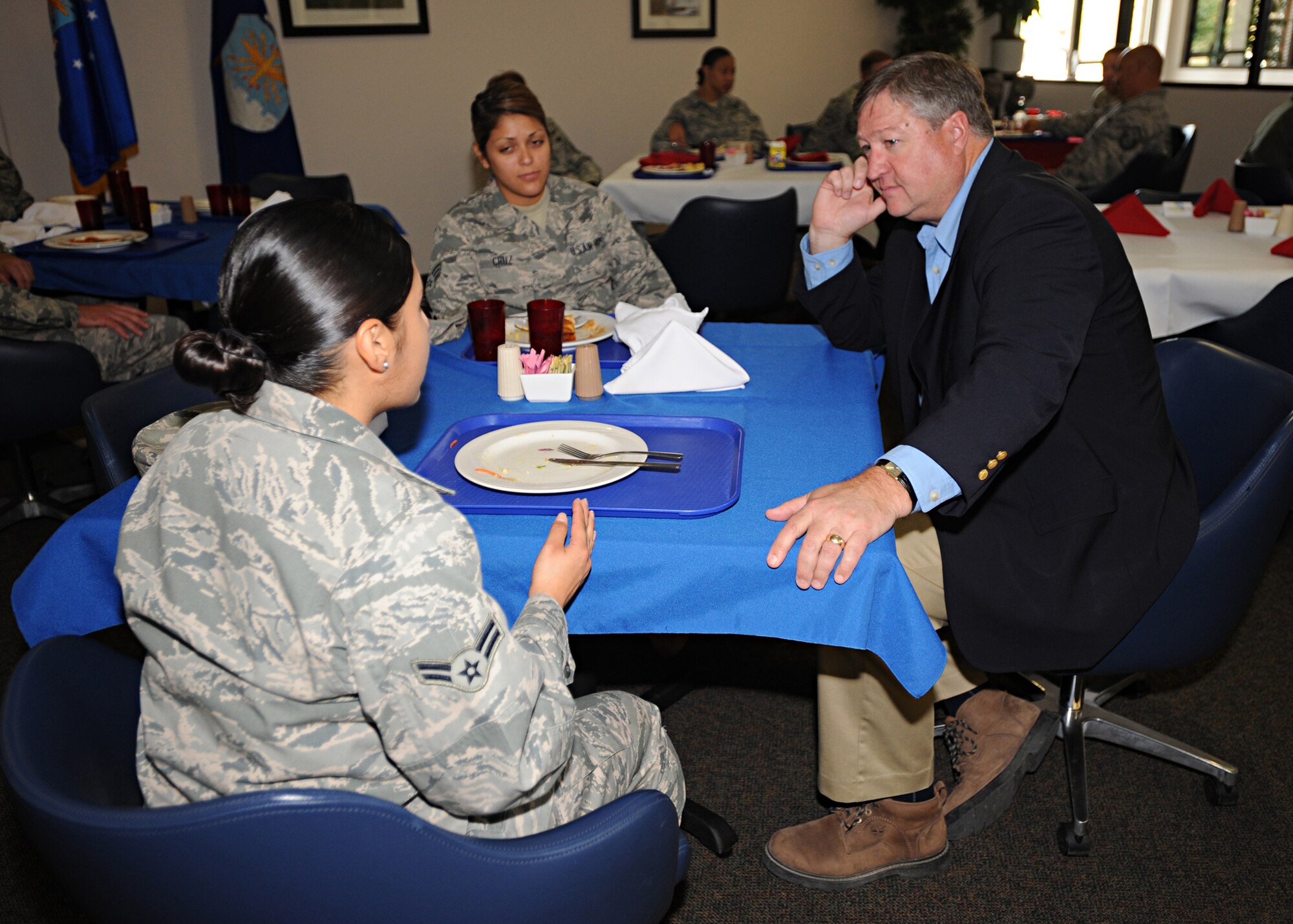 Secretary of the Air Force Michael Donley listens to Airman 1st Class Mabel Fuentes (left), 27th Special Operations ForceSupport Squadron during breakfast at Cannon Air Force Base, N.M Pecos Trail Dining Facility. With them is Senior Airman Krysta Cruz, 27th Special  Operations Support Squadron. The Air Force secretary went from table to table, and listened to and answered questions from Airmen. (U.S. Air Force photo by Senior Airman Maynelinne De La Cruz)