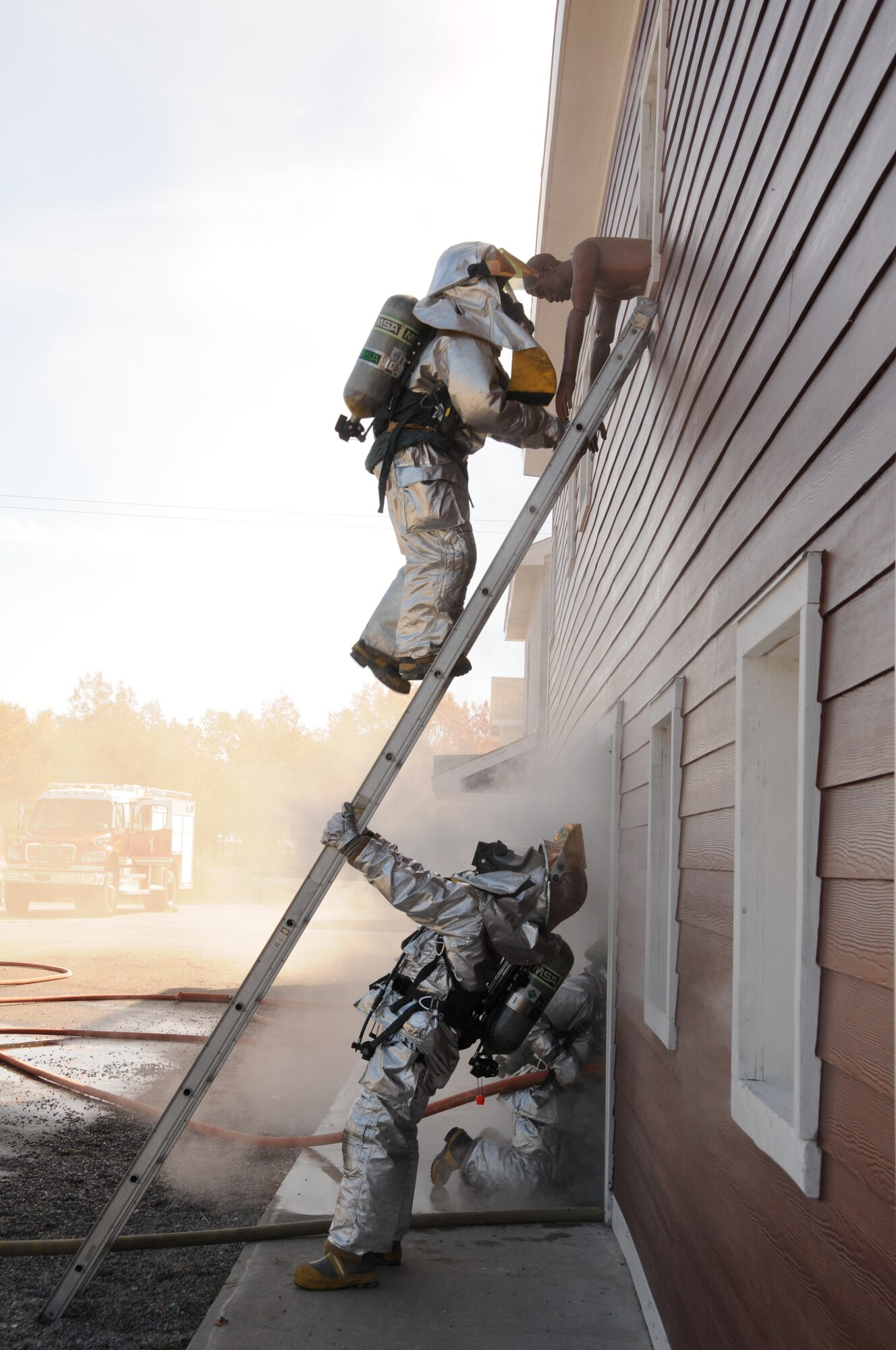 U.S. Air Force firefighters from the 180th Fighter Wing, rescue simulated victims from a burning building during a training exercise at the Phelps Collins Combat Readiness Training Center, Alpena, Michigan, October 16, 2010.  Firefighters from the 180 FW are doing annual training to prepare them for various rescue situations. (U.S. Air Force photo by Senior Airman Amber Williams/Released)