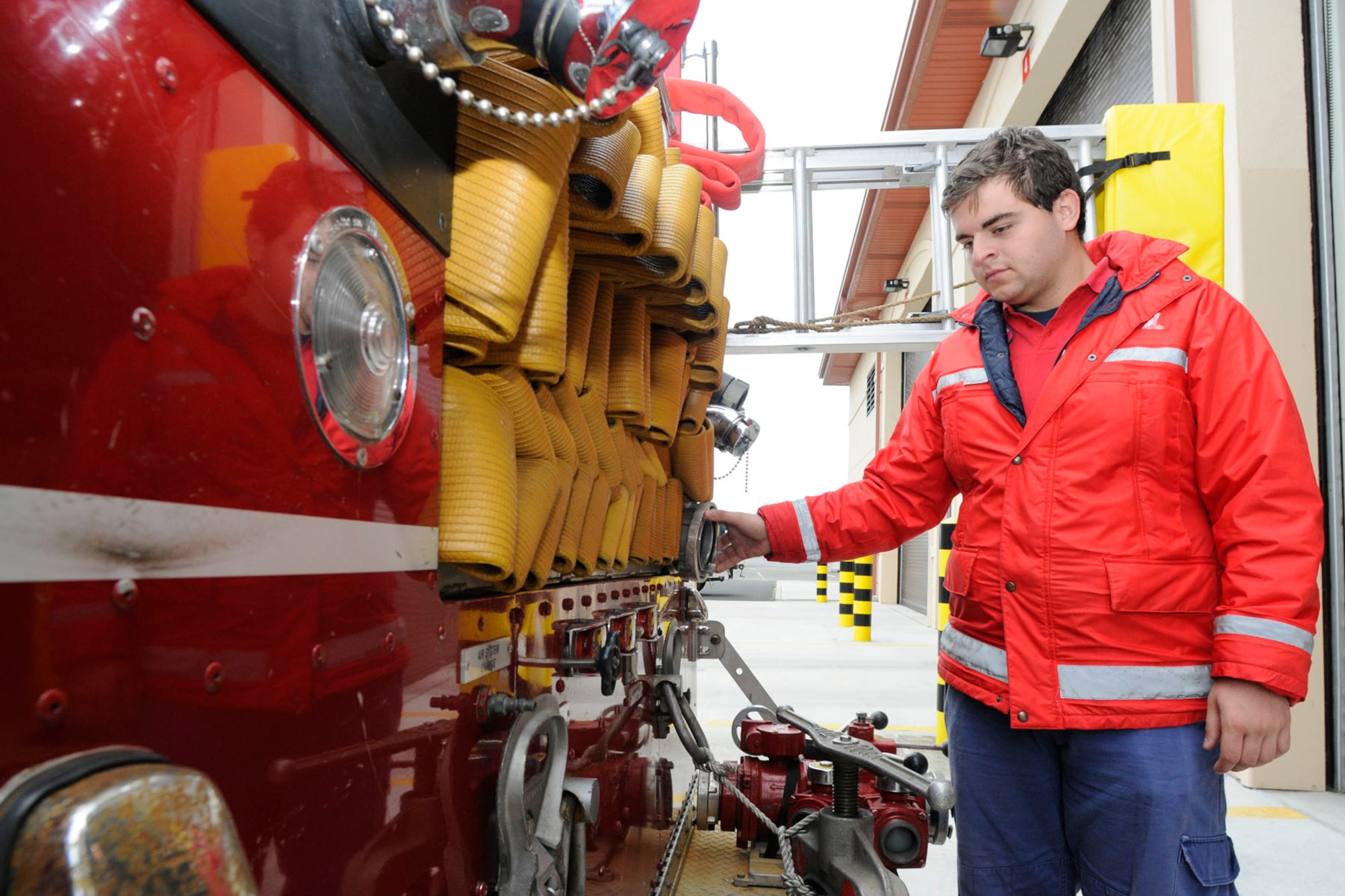 Pedro Barcelos, a local volunteer firefighter from Praia da Vitoria, looks a at a three-inch hose on the back of an Air Force fire truck, Oct. 9, 2010.  The Air Force uses equipment that is different from off-base besides the fact the Air Force uses inches and feet and the Azores, Portugal use centimeter and meters. (U.S. Air Force photo by Tech. Sgt. Chyrece Campbell)