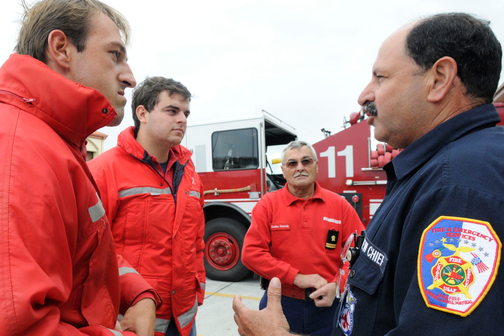 Dimas Martins, 65th Civil Engineer Squadron fire department crew chief, talks to local off-base firefighters during a visit to the Lajes Fire station, Oct. 9, 2010.  More than 10 local firefighters from Praia, Angra and Altares visited Lajes Field to participate in the Fire Prevention Week parade and collaborate with U.S. firefighters.  (U.S. Air Force photo by Tech. Sgt. Chyrece Campbell)