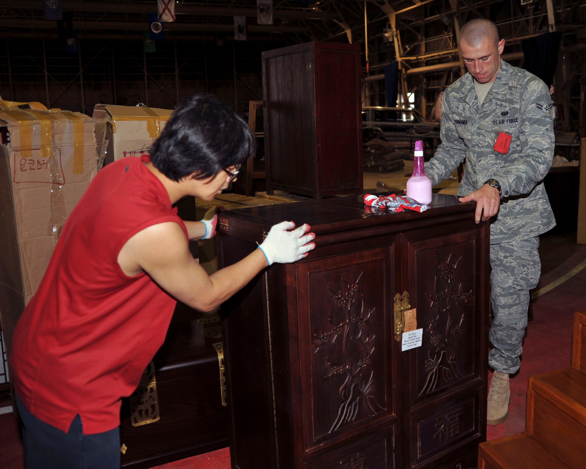 U.S. Air Force Airman 1st Class Joshua Formanek, right, 373rd Support squadron client support computer systems, assists a furniture vendor set up his display at the Far East Bazaar at Misawa Air Base, Japan, Oct. 13, 2010. More than 250 volunteers gave their time and effort to assist in setting up the bazaar. (U.S. Air Force photo by Tech. Sgt. Russell McBride/Released)