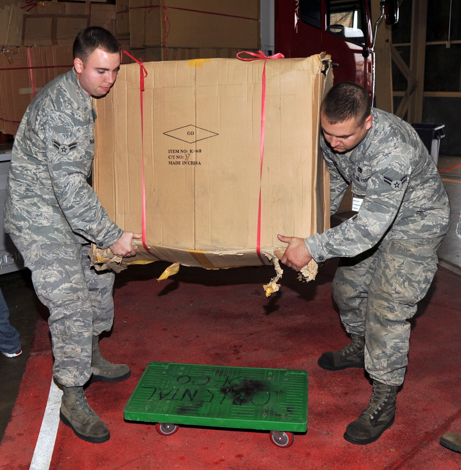 U.S. Air Force Airman 1st Class Joshua Matheson, left, 35th Maintenance Squadron propulsion flight, and Airman 1st Class James Lane, 35 MXS/MXMMP, lower furniture on to a dolly as they help set up for the Far East Bazaar at Misawa Air Base, Japan, Oct. 15, 2010. Most of the proceeds were donated to various charitable organizations on base and around the world. (U.S. Air Force photo by Tech. Sgt. Russell McBride/Released)