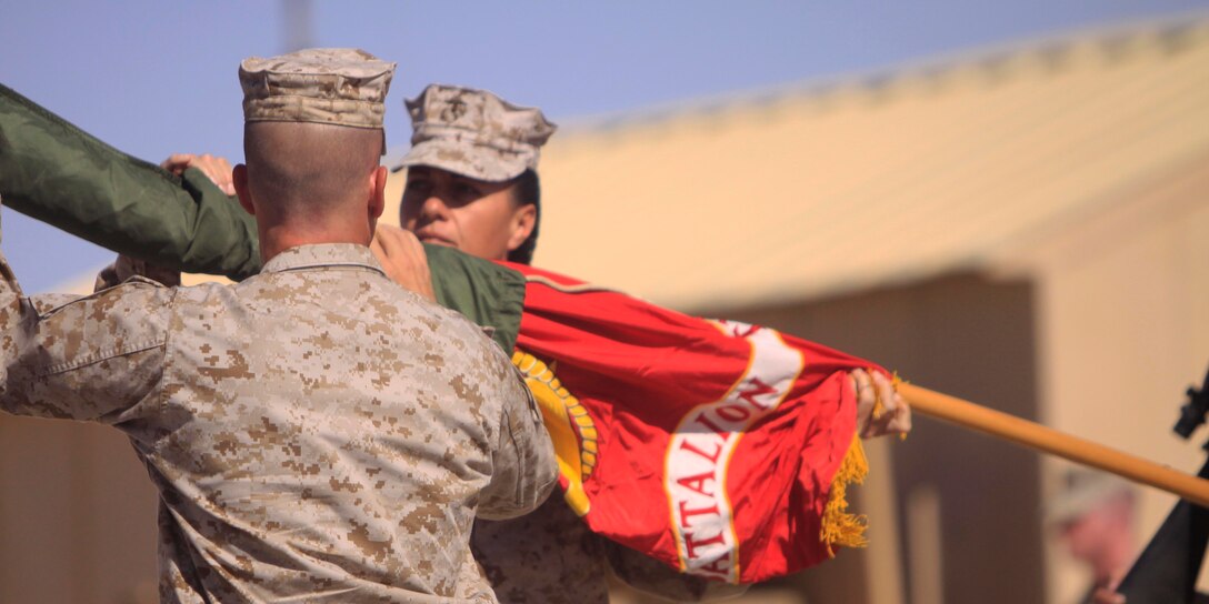 Sergeant Major Angela M. Maness (right), battalion sergeant major, Combat Logistics Battalion 3, 1st Marine Logistics Group (Forward), and Lt. Col. Henry W. Lutz I I I , commanding officer, CLB-3, 1st MLG (FWD), uncase CLB-3’s organizational colors during a transfer of authority ceremony at Camp Dwyer, Afghanistan, Oct. 18.