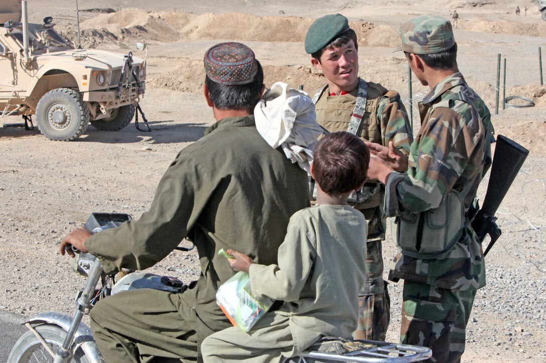 Afghan National Army soldiers talk to Afghan citizens driving by on Route 606 in Demazong, Afghanistan, Oct. 18. Marines and Afghan soldiers checked passing vehicles for contraband, including improvised explosive devices and materials used to make IEDs, the Taliban’s weapon of choice against coalition forces.