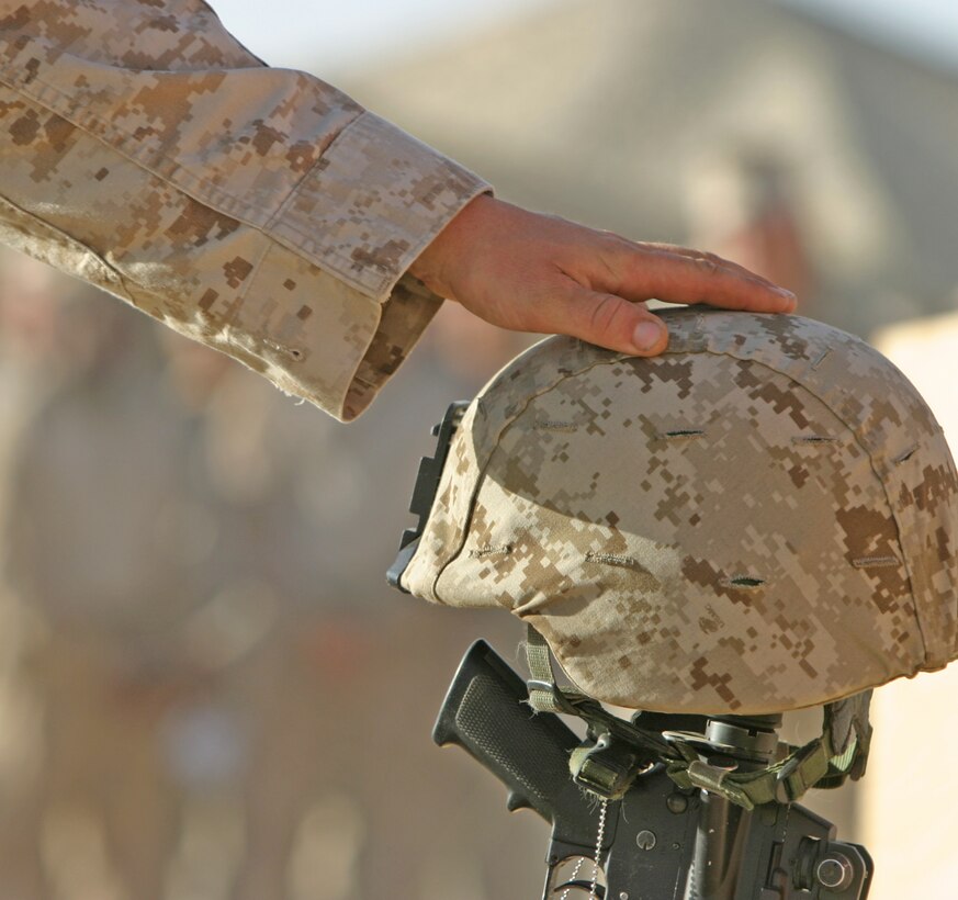A Marine with 2nd Battalion, 9th Marine Regiment, touches the helmet of Sgt. Frank R. Zaehringer, an anti-tank missile-man with Weapons Company, 2/9, Oct. 19, during a memorial service at Forward Operating Base Camp Hanson, Helmand Province, Afghanistan. Zaehringer’s life was tragically ended Oct. 11, while conducting combat operations in Northern Marjah.
