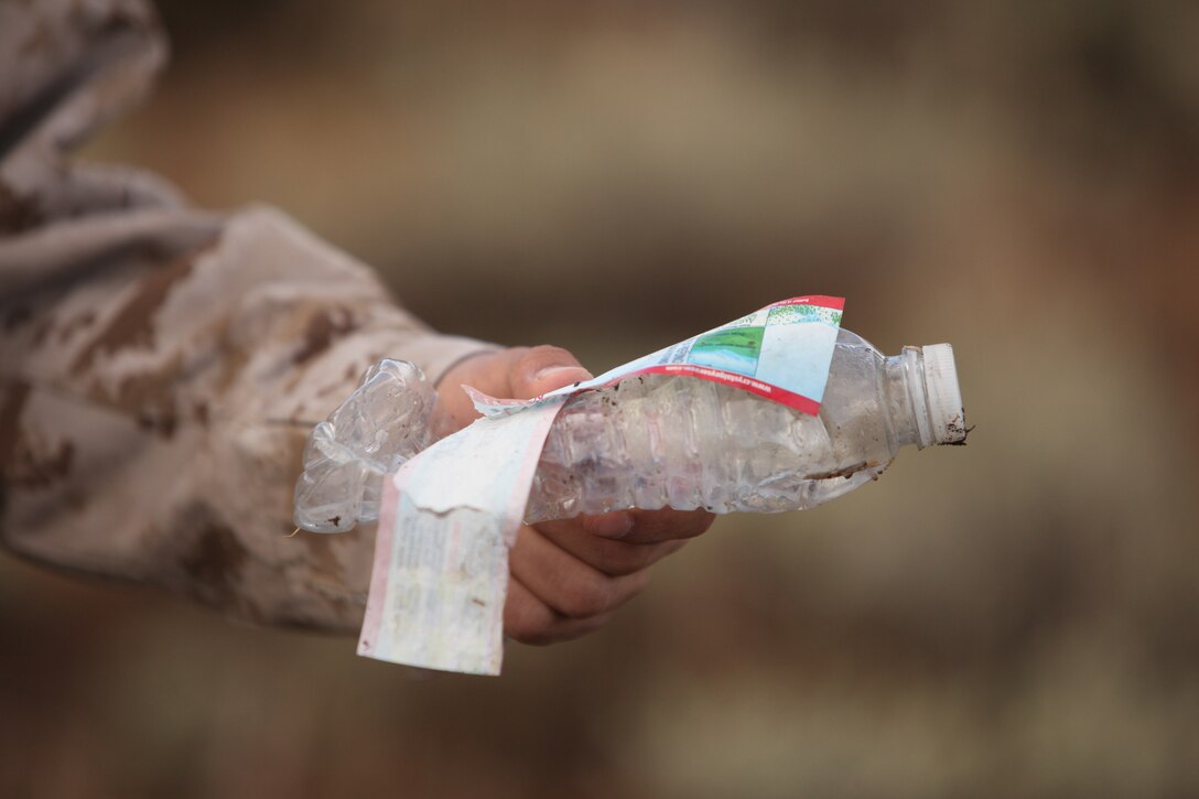 A Marine aboard the Mountain Warfare Training Center picks up a littered water bottle in the Toiyabe National Forest Oct. 18. The Marines joined together to clean up the national forest and keep it safe for wildlife.::r::::n::