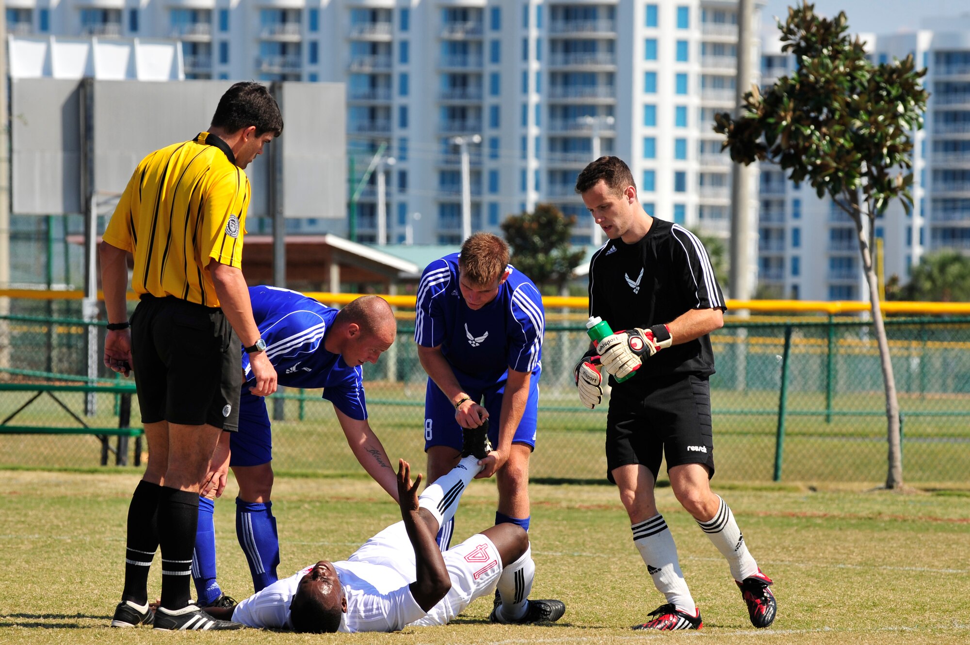 U.S. Air Force soccer team players assist U.S. Marine Corps Private 1st Class Tinashe Ngwenya, assigned to Marine Corps Base Camp Butler, Okinawa, Japan, during a 2010 Armed Forces Soccer Championship Round Robin match, Destin, Fla., Oct. 19, 2010. Each team conducted highly competitive training programs and trial camps in order to select the best players to represent their respective services.  However, at the conclusion of the tournament, inter-service rivals will cast aside their differences.  The top players from the tournament will be chosen to represent the US in the International Military Sports Competition.   (DoD Photo by Staff Sgt. Stephanie Jacobs/RELEASED)

