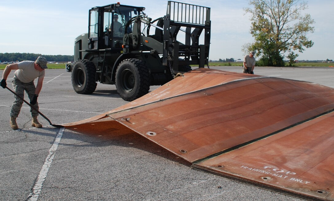 Reservists of the 932nd Civil Engineer Squadron practice rapid runway repair using 
fiberglass matting.  The fold-out matting can be quickly deployed over craters and large holes keeping the runway usable for aircraft operations. The civil engineers were preparing for an upcoming readiness inspection during the September Unit Training Assembly. (U.S. Air Force photo/Senior Airman Jessica Davila-Caba)  