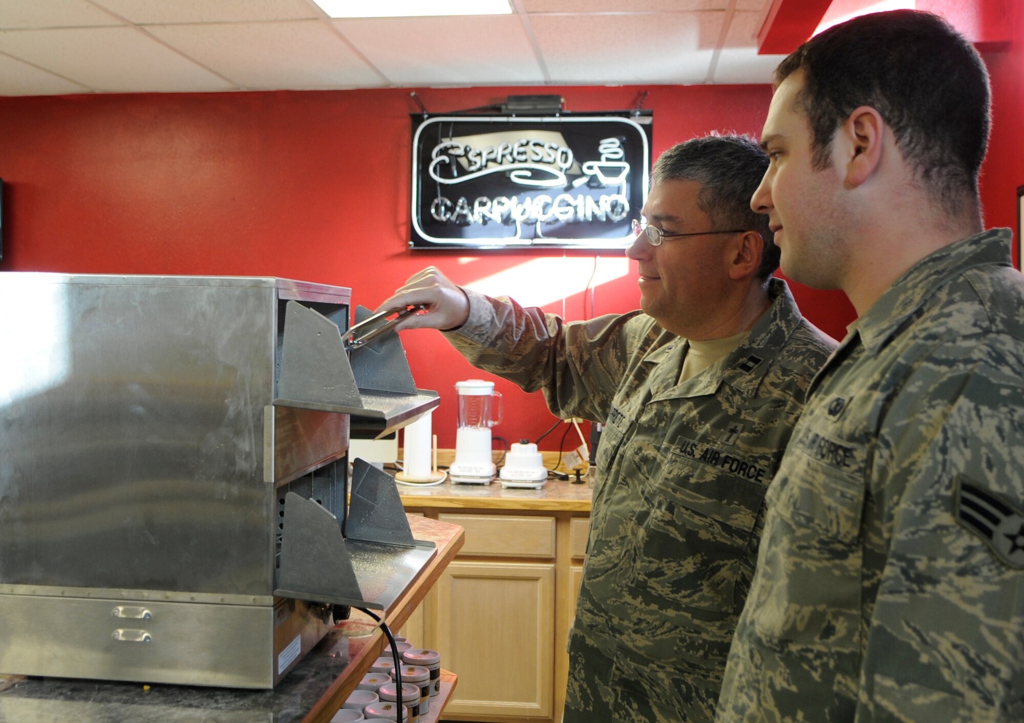 Chaplain (Capt.) Jesus Navarrete and Senior Airman Anthony Yannielli  inspect one of the new additions to the North Star Café Oct. 14, 2010, at Eielson Air Force Base, Alaska.  Upgrades done to the Café include the additions of new televisions, a hotdog machine, and a popcorn machine.  Father Navarrete is the 354th Fighter Wing Chapel Services Catholic Priest.  Senior Airman Yannielli is a chaplain assistant assigned to the 354th Fighter Wing Chapel Services.  (U.S. Air Force photo by/Airman 1st Class Yash Rojas)    