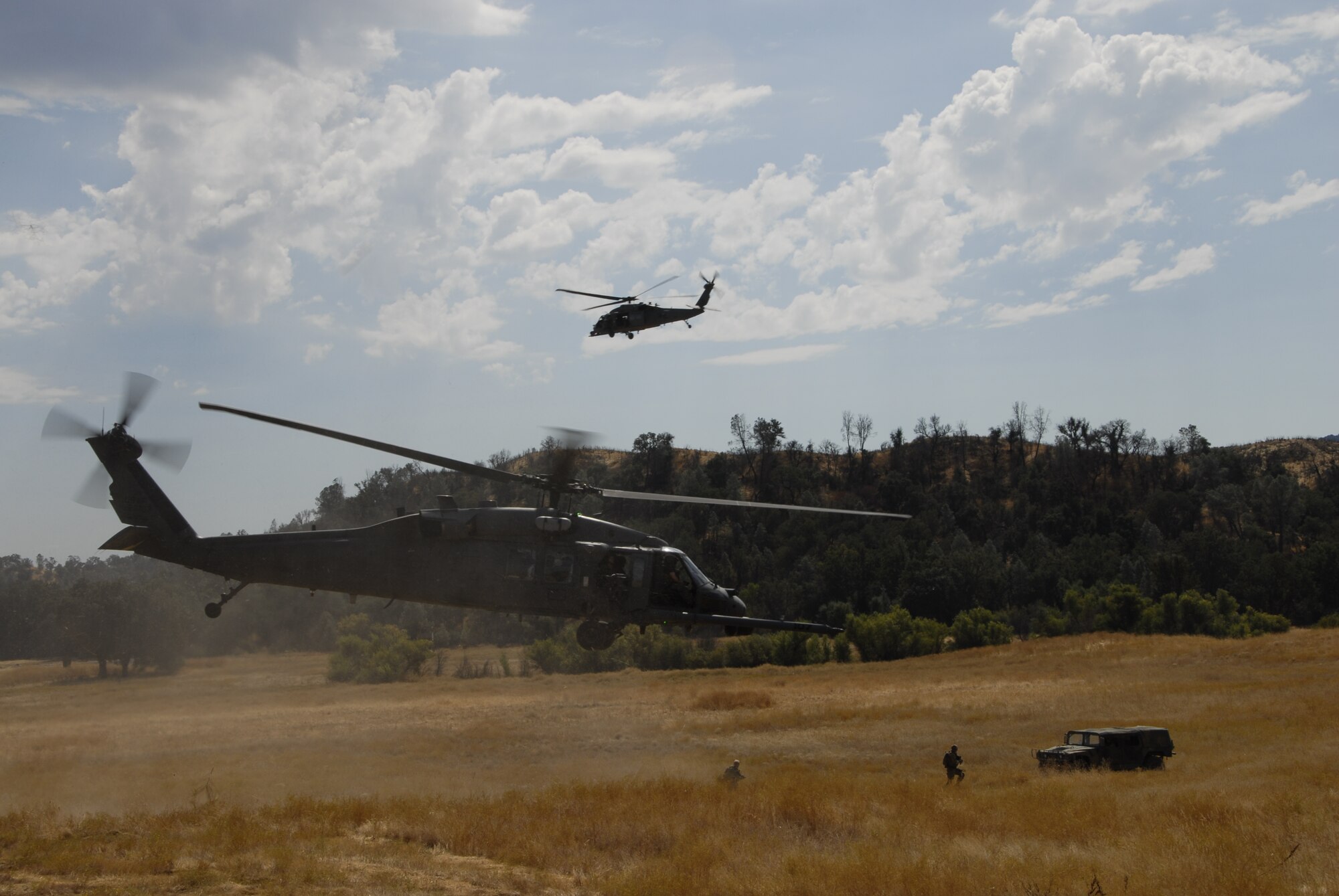 Two HH-60G Pave Hawk rescue helicopters land outside an urban assault course at Fort Hunter Liggett, Calif. Oct. 2, 2010 to pick up a hostage during a recovery scenario as part of Soaring Angel 10-2. Soaring Angel is the 129 Rescue Wings tactical training exercise in preparation for their upcoming Operational Readiness Inspection in Dec. 2011. (Air National Guard photo by Airman 1st Class Jessica Green)