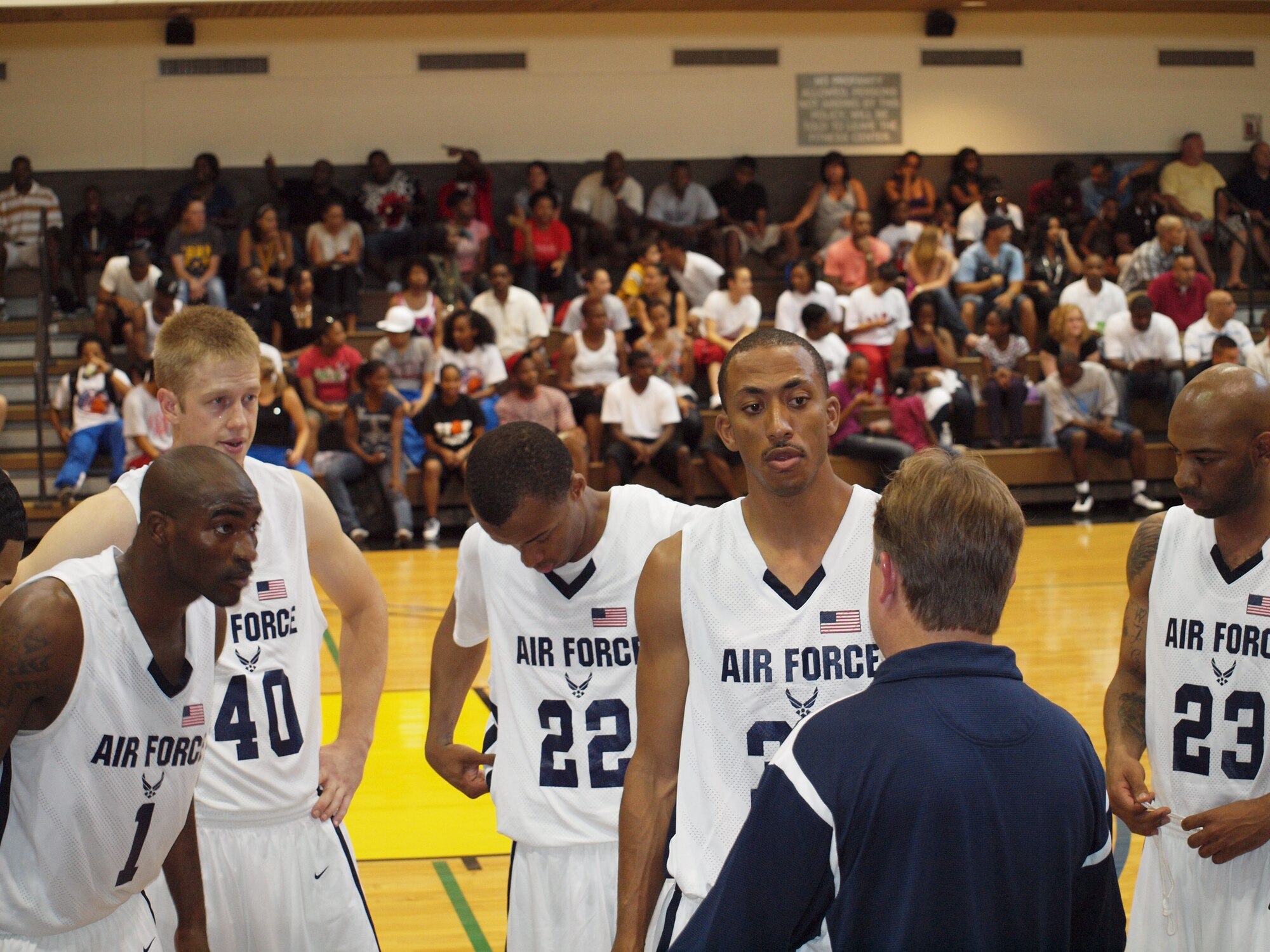 James Lewis, a Senior Airman with the 460th Comptrollers Squadron, stands in the huddle (left) during the Armed Forces Basketball Tournament. Lewis, who played professionally for four years in Germany, helped the team to it's fourth championship in as many years. (Courtesy photo)