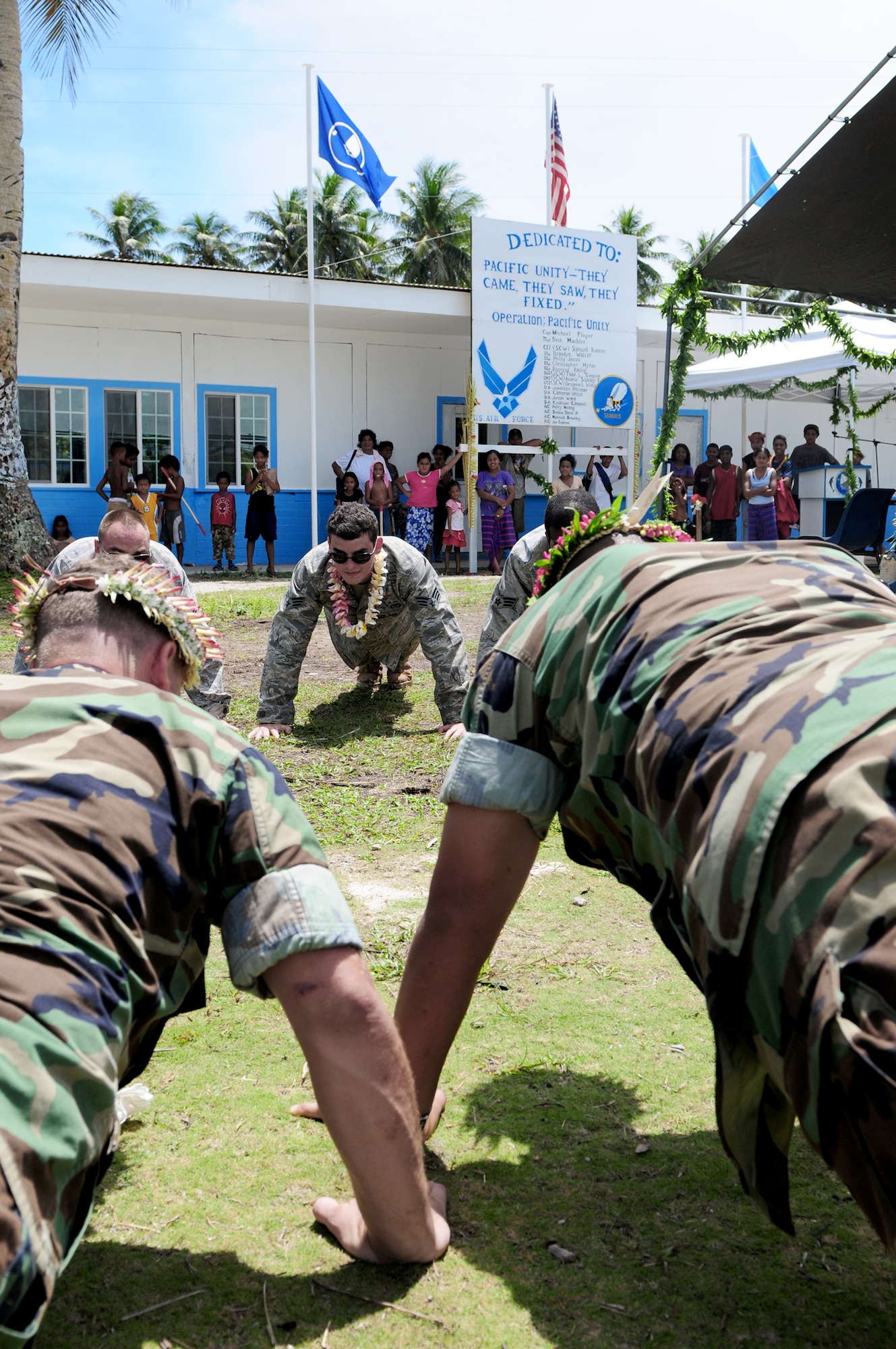 U.S. Air Force civil engineers from Yokota, Japan, and U.S. Navy Seabees from San Diego, Calif., gather Sept. 22, 2010, for their last tribute to the islanders of Yap, Federated States of Micronesia, as they perform group push-ups during Pacific Unity 2010. Pacific Unity 2010 is a humanitarian civil engineering effort in which civil engineers completely rebuilt, remodeled and repainted a high school on a remote island in Micronesia. (U.S. Air Force photo/Master Sgt. Victoria Meyer)