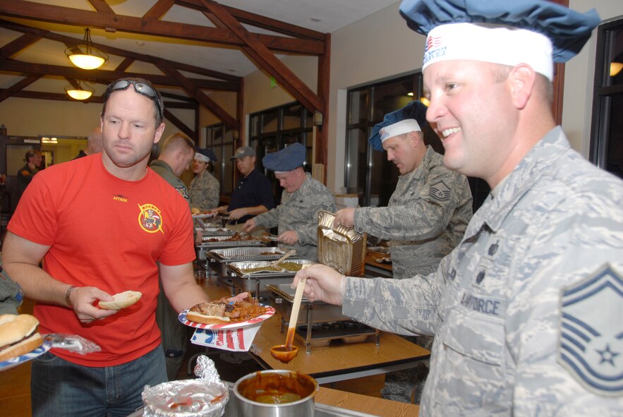 Senior Master Sgt. Travis Stickels, right, serves up some barbecue sauce for Lt. Col. Anthony Roe during dinner Oct. 14 at Hawgsmoke 2010.  Sergeant Stickels, Master Sgt. Ralph Kowski, Tech. Sgt. David Lawson and Airman Jennifer Rehmer, all from the 442nd Services Flight, drove more than 1,400 miles with 500 pounds of meat and 10 gallons of baked beans to feed more than 300 Hawgsmoke participants, including 303rd Fighter Squadron A-10 pilot, Colonel Roe.  Hawgsmoke is a bienial competition among the U.S. Air Force's A-10 squadrons that tests pilots' bombing, gunnery, navigation and aviation skills.  The 2010 competition was hosted by the 124th Fighter Wing, Idaho Air National Guard, at Gowen Air National Guard Base, Idaho.  The 124th FW's 190th Fighter Squadron won the competition just as it did in 2008.  (U.S. Air Force photo/Lt. Col. David Kurle)