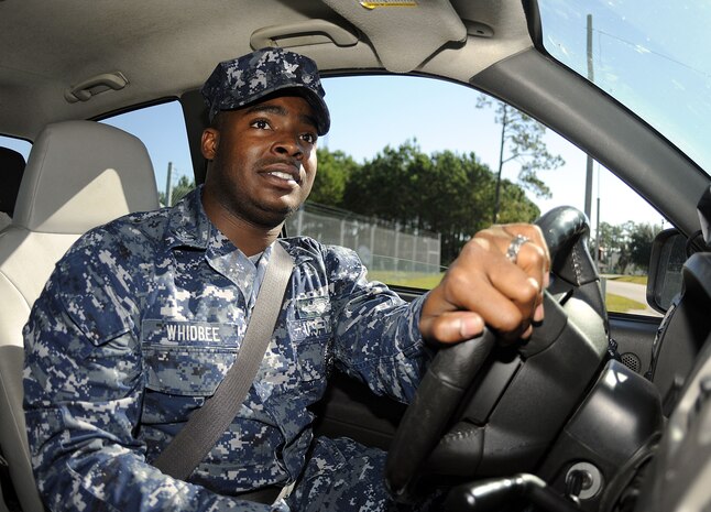 Master-at-Arms 2nd Class Sherman Whidbee pulls out of the security department?s parking lot ready to start his day at Joint Base Charleston-Weapons Station. (U.S. Navy photo/Mass Communication Specialist 1st Class Jennifer Hudson)