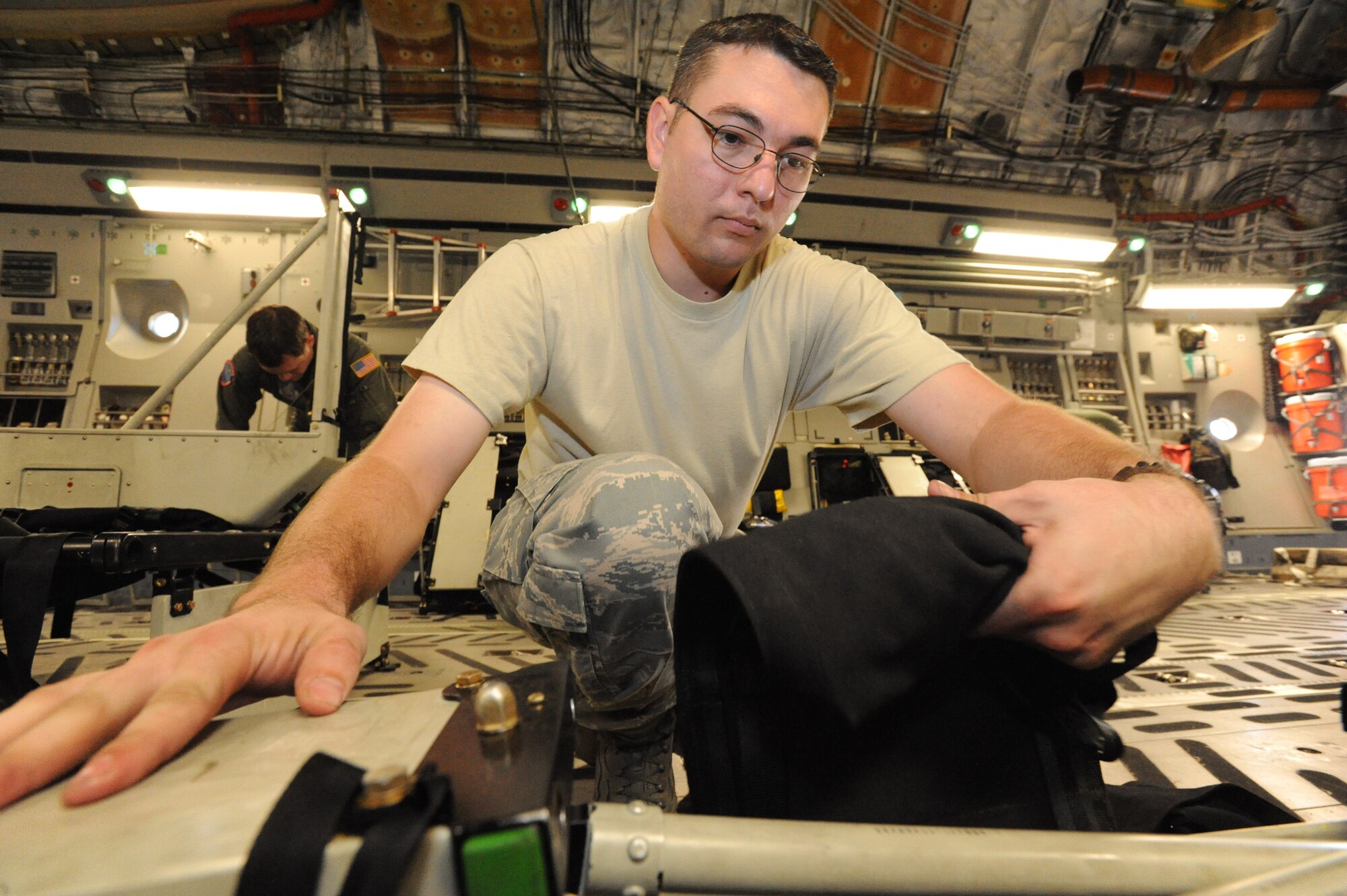 Staff Sgt. Joseph Leugers, 15th Aircraft Maintenance Squadron flying crew chief, breaks down center seats in a C-17 in preparation for transport Oct. 10. A C-17 Globemaster III from the 15th Wing at Joint Base Pearl Harbor-Hickam made the long journey to Fort Benning to support the student jump requirements of the 507th Airborne School. (U.S. Air Force photo/Staff Sgt. Nathan Allen) 

